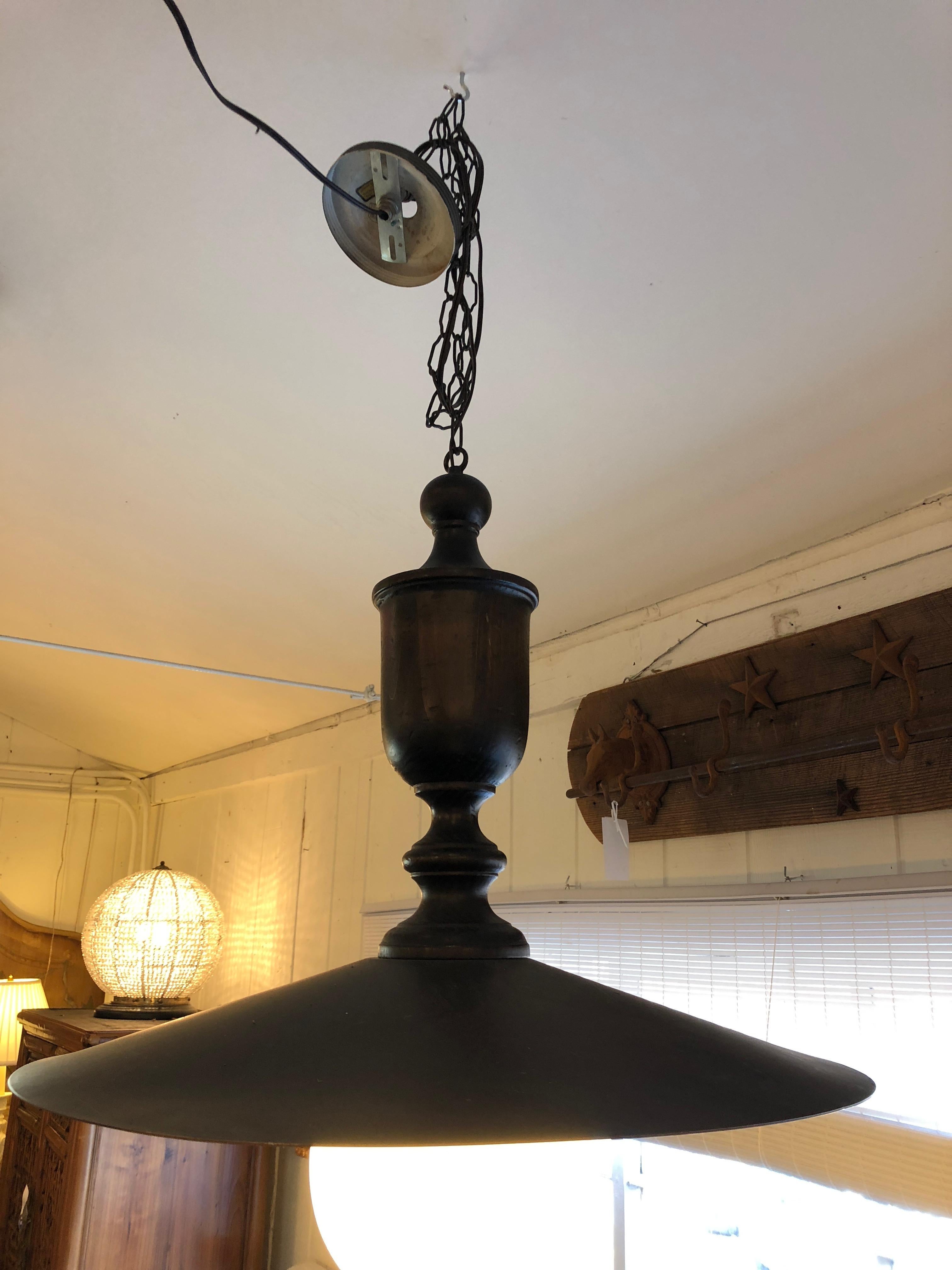 Handsome dark brown industrial style metal chandelier having round illuminated globe.