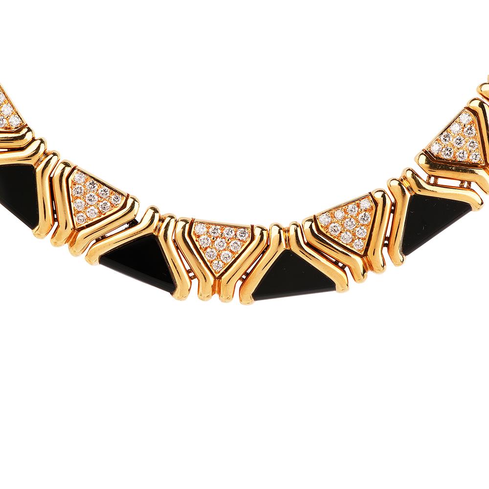 This stylish circa 1970's diamond and onyx choker necklace is crafted in solid 18-karat high polish yellow gold, weighing 196.8 grams and measuring 16mm wide. Exposing nine links pave-set in 90 round-cut diamonds, collectively weighing