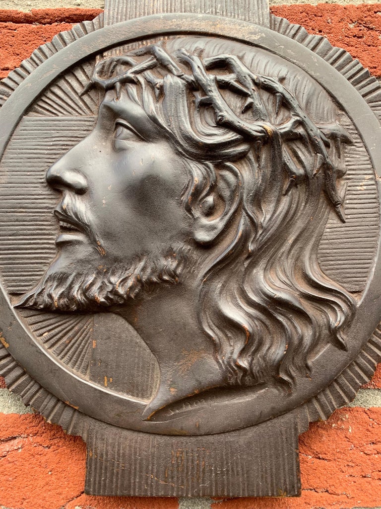Beautifully handcrafted and meaningful religious plaque.

This heavy and high quality bronze wall plaque depicts Christ with a realistic crown of thorns and a stylized Art Deco halo on the outside. This religious work of art in deep relief is signed