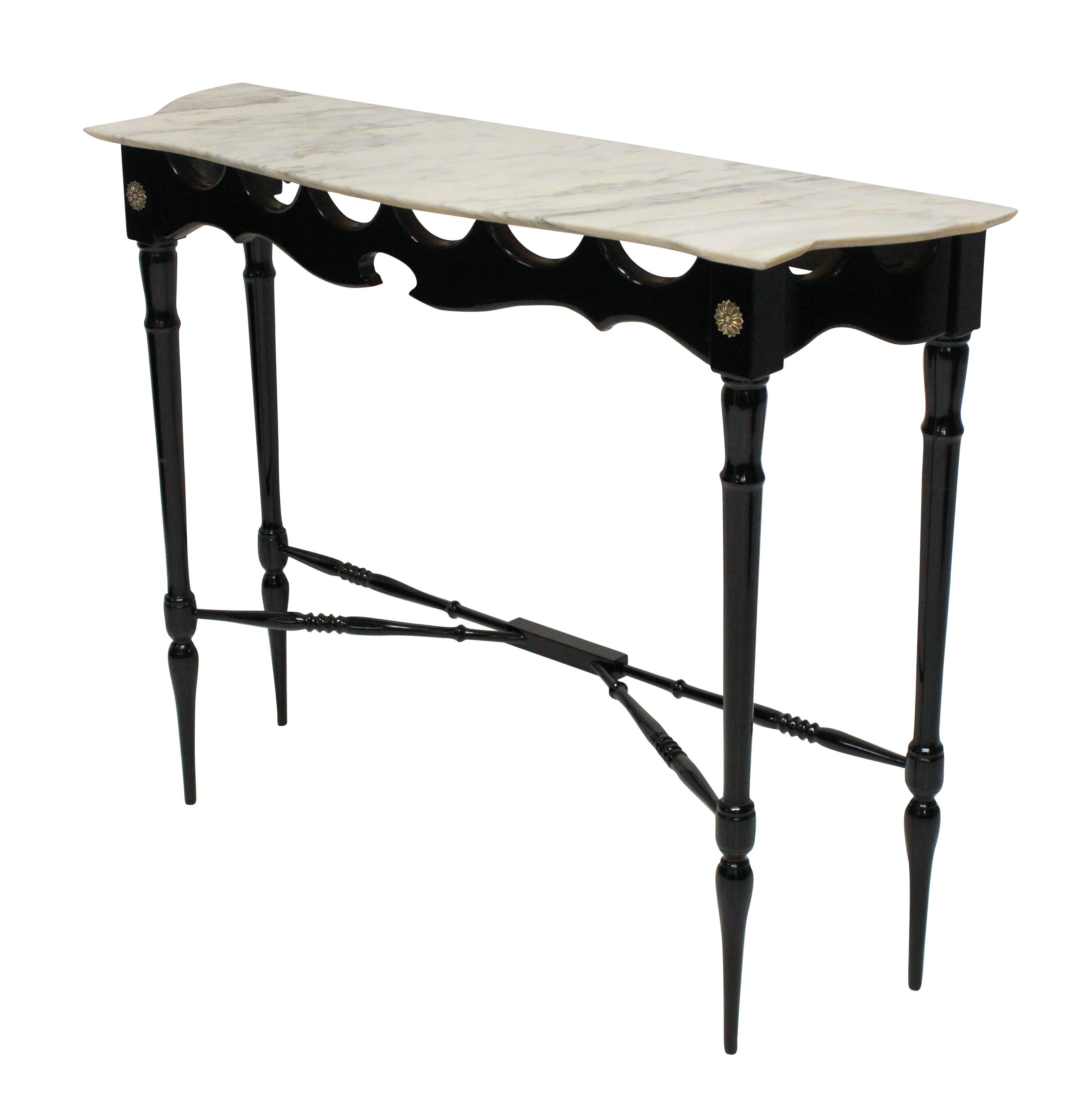 A stylish Italian midcentury console table of unusual design. In ebonized and polished wood with a pale cream veined marble top.

 
