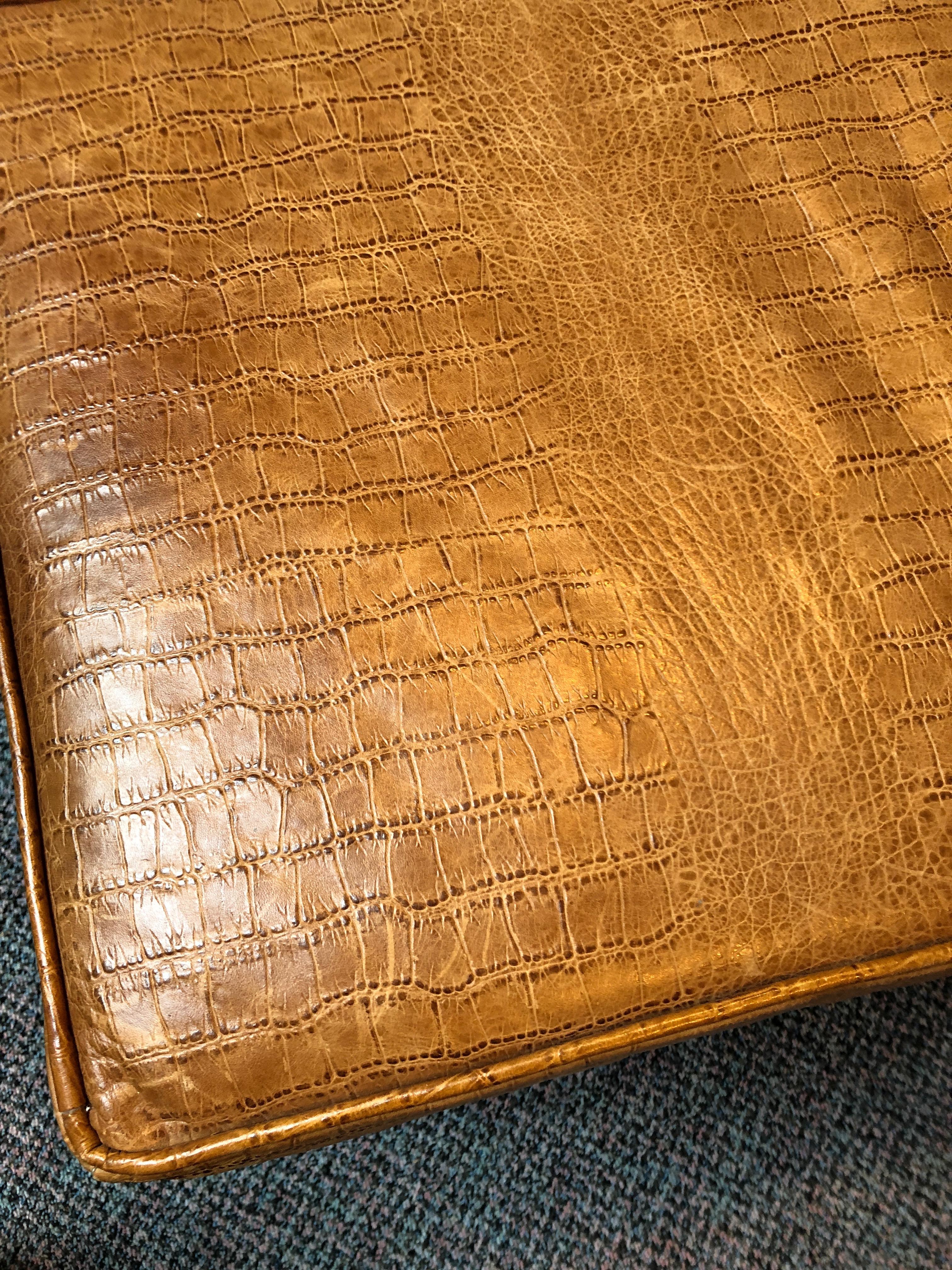 Handsome sleek bench of embossed leather that looks like crocodile in a rich caramel color. Contemporary simple lines and dark brown wooden base.