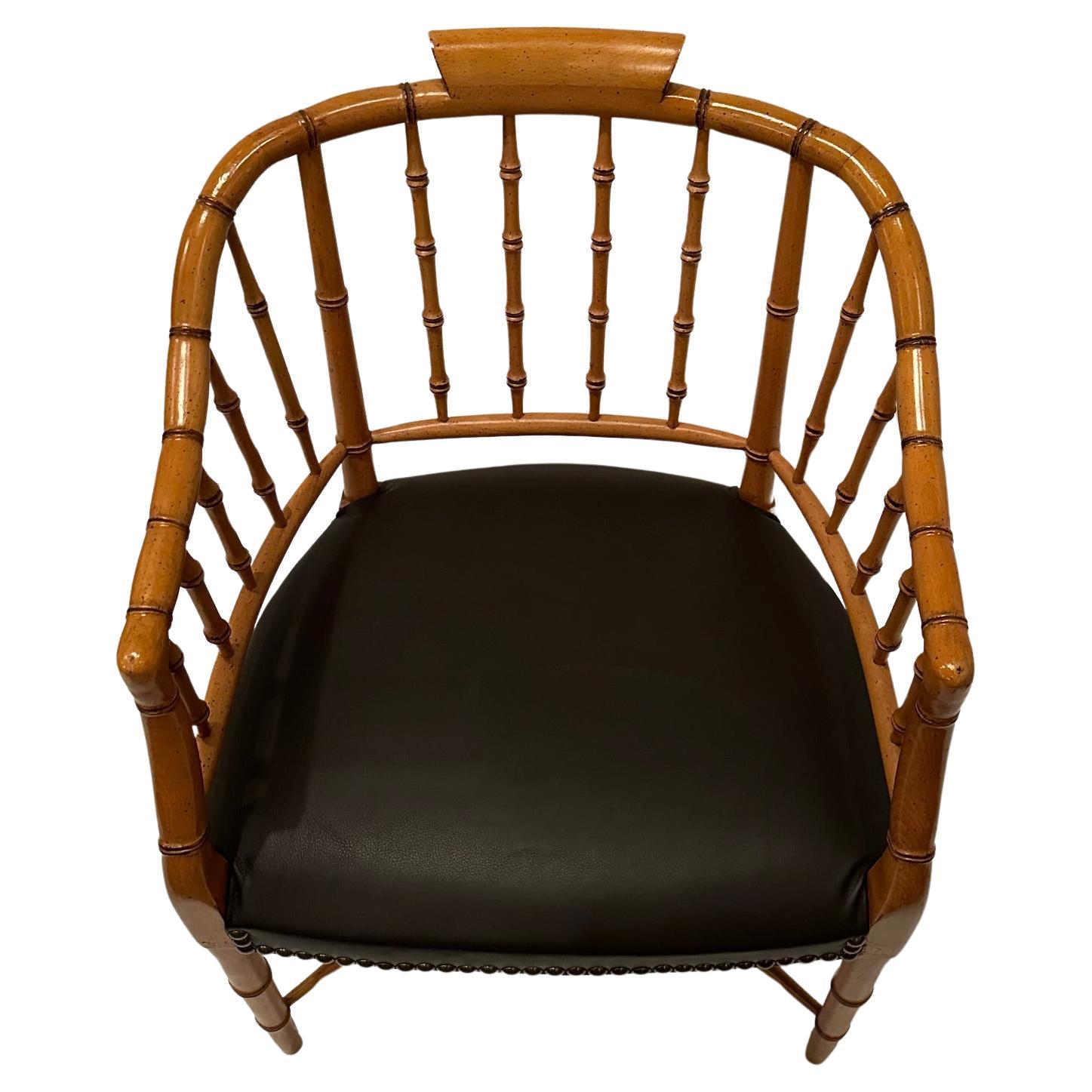 Sophisticated faux bamboo armchair newly upholstered in chocolate leather and finished with brass nailheads.  arm height 27
