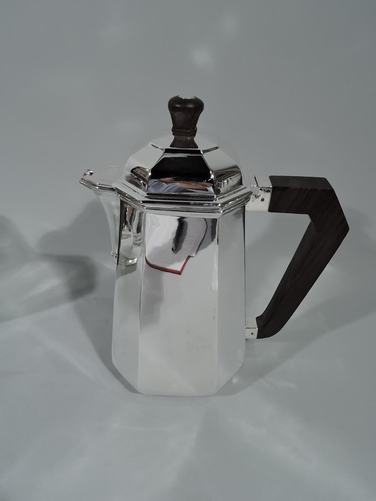 French Art Deco modern 950 silver coffee and tea set. This set comprises coffeepot, teapot, creamer, and sugar.

Each: Upward tapering body with alternating wide and narrow facets. Covers same and raised with stained-wood finial. Spouts faceted
