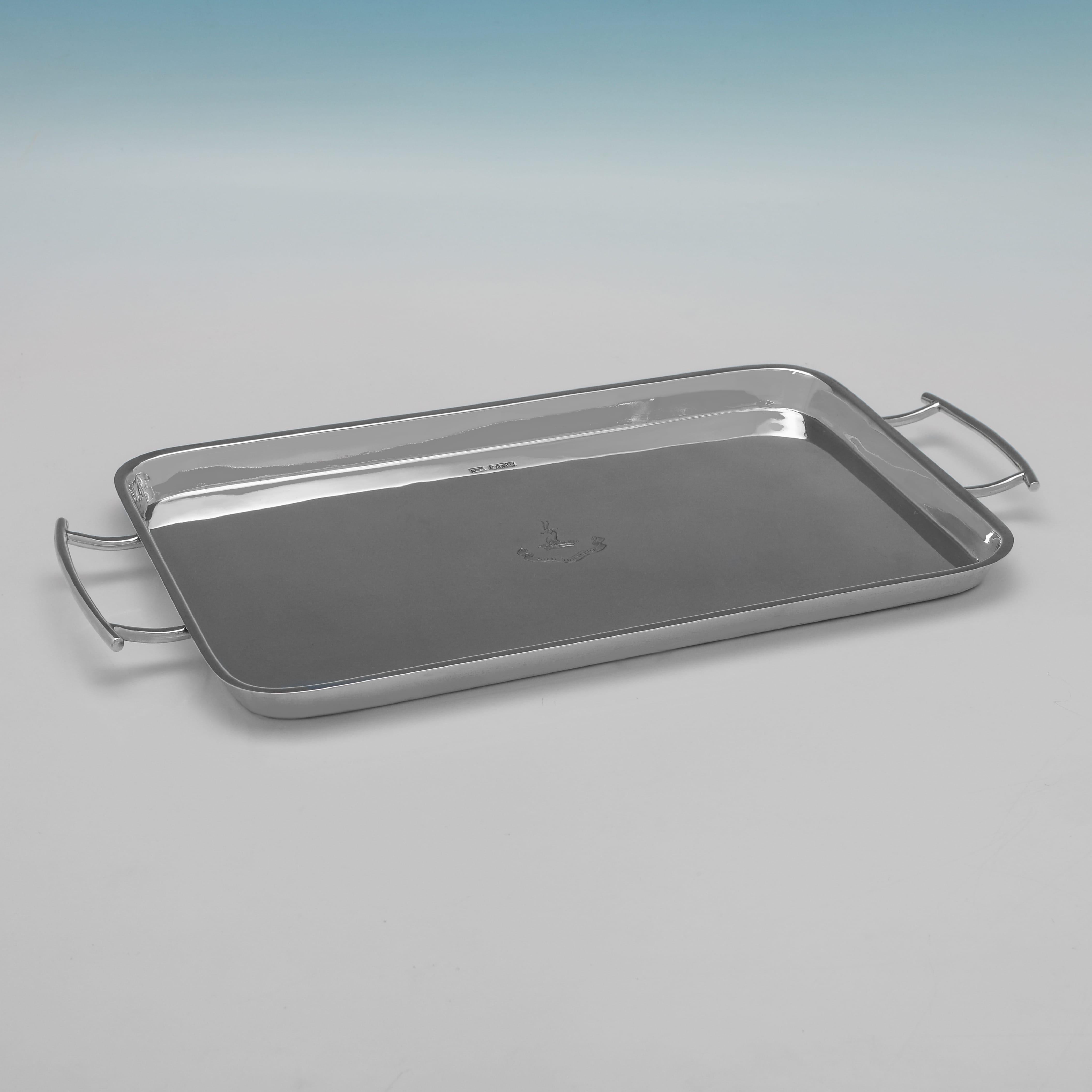 Hallmarked in Sheffield in 1920 by Walker 
Hall this understated George V antique sterling silver bar tray is of a rectangular form with rounded corners, a polished surface, and plain angular handles. The centre of the tray is engraved with a