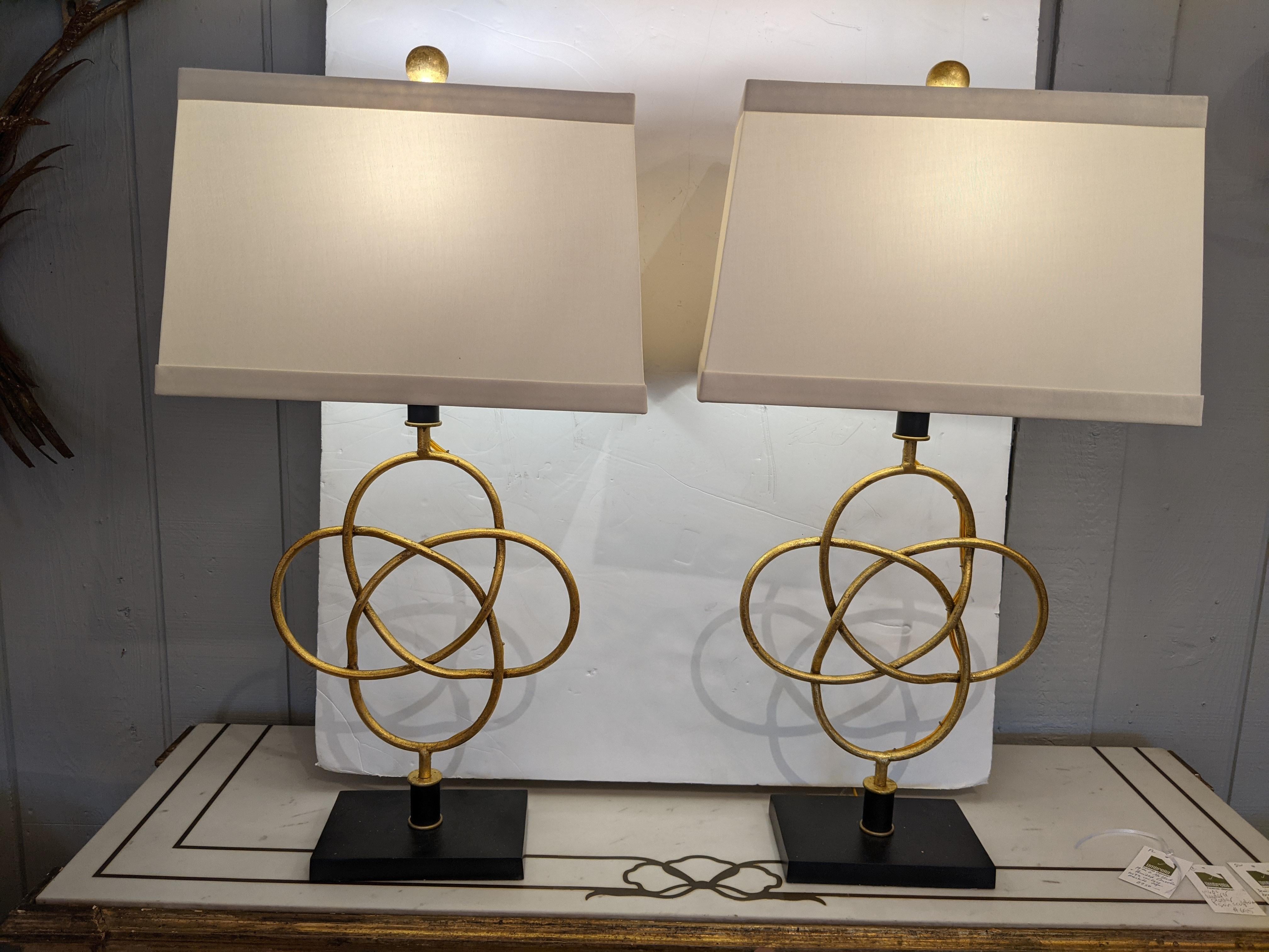 Beautiful pair of contemporary lamps having gilt metal sculptural overlapping ovals on a black base. Custom shades included.
lamps are 13