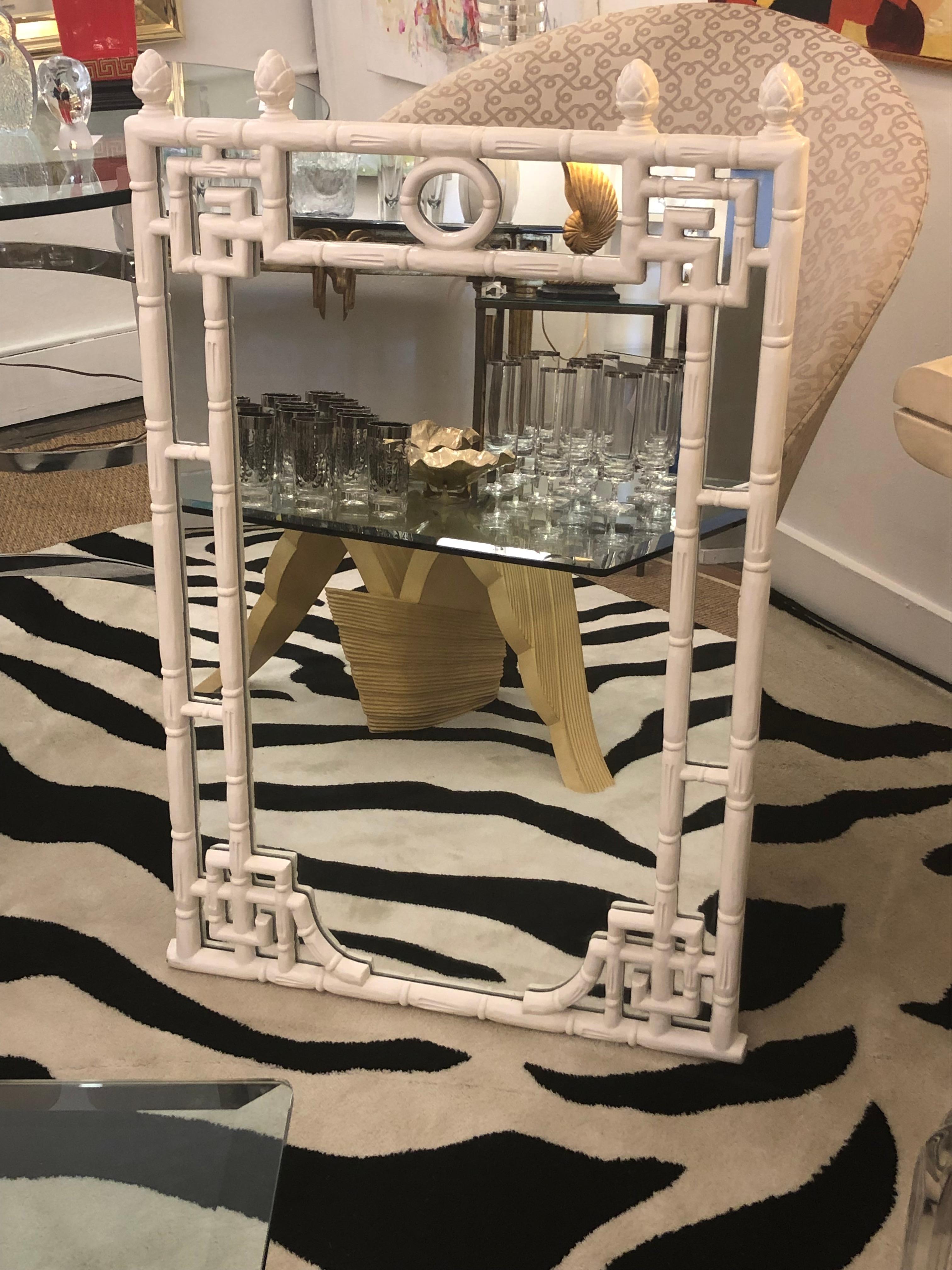 Stylish white painted faux bamboo Hollywood Regency mirror having greek key decoration in the corners and acorn finials at the top. Turner label on the back.