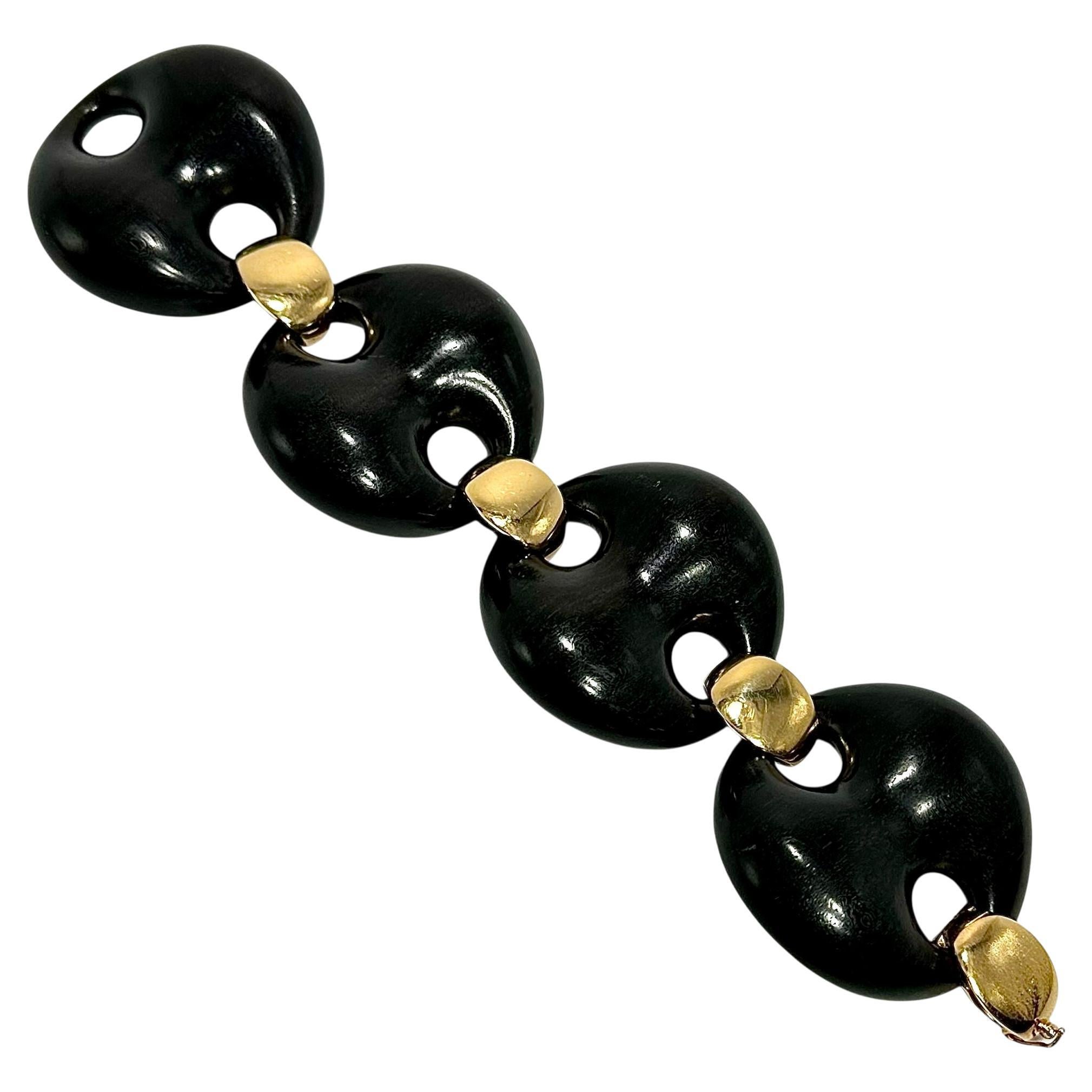 Esta imaginativa y extravagante pulsera de eslabones grandes de ébano y oro amarillo de 18 quilates es toda una declaración de intenciones. Siempre que vemos joyas innovadoras elaboradas por expertos, sospechamos que son de origen italiano y, rara