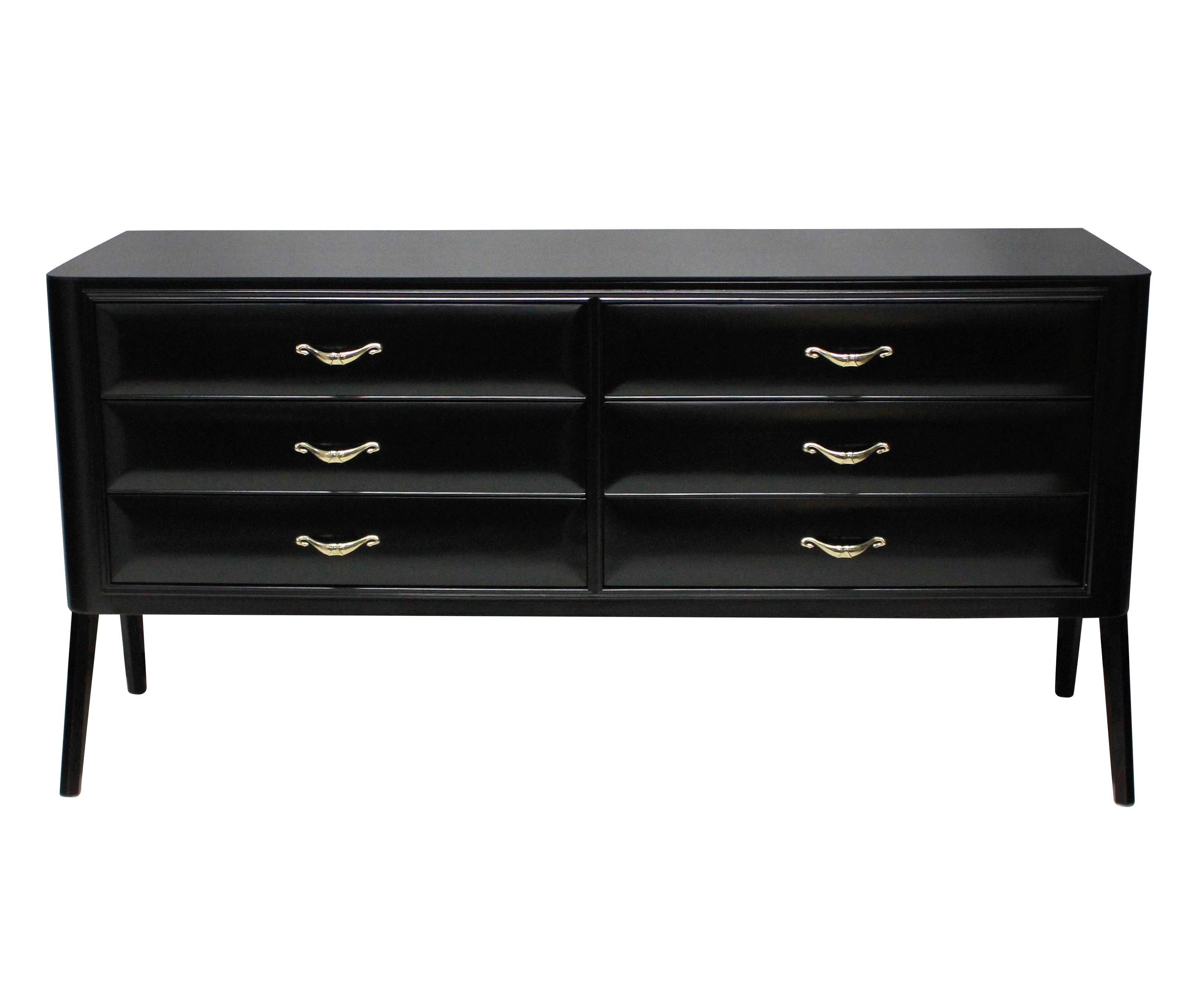 An Italian credenza in black satin finish lacquer, comprising six drawers with fine brass handles. The top of black glass and with architectural side panel legs.