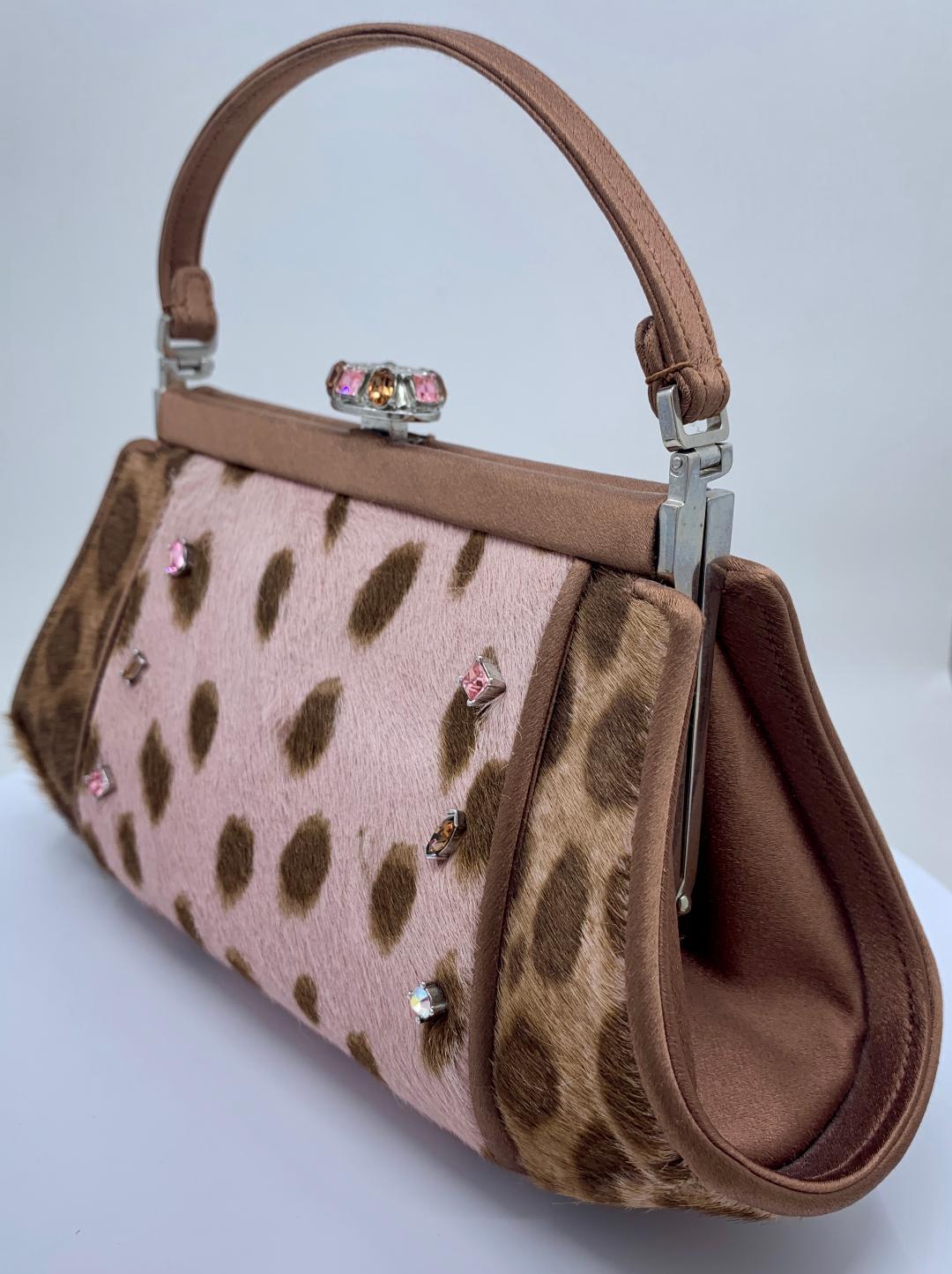 Very stylish and fun, couture designer, Judith Leiber, pony hair leopard print evening purse with hand set jeweled accents, coco brown satin piped trim and matching handle. Purse is lined in a coco brown satin and features a fancy multi colored