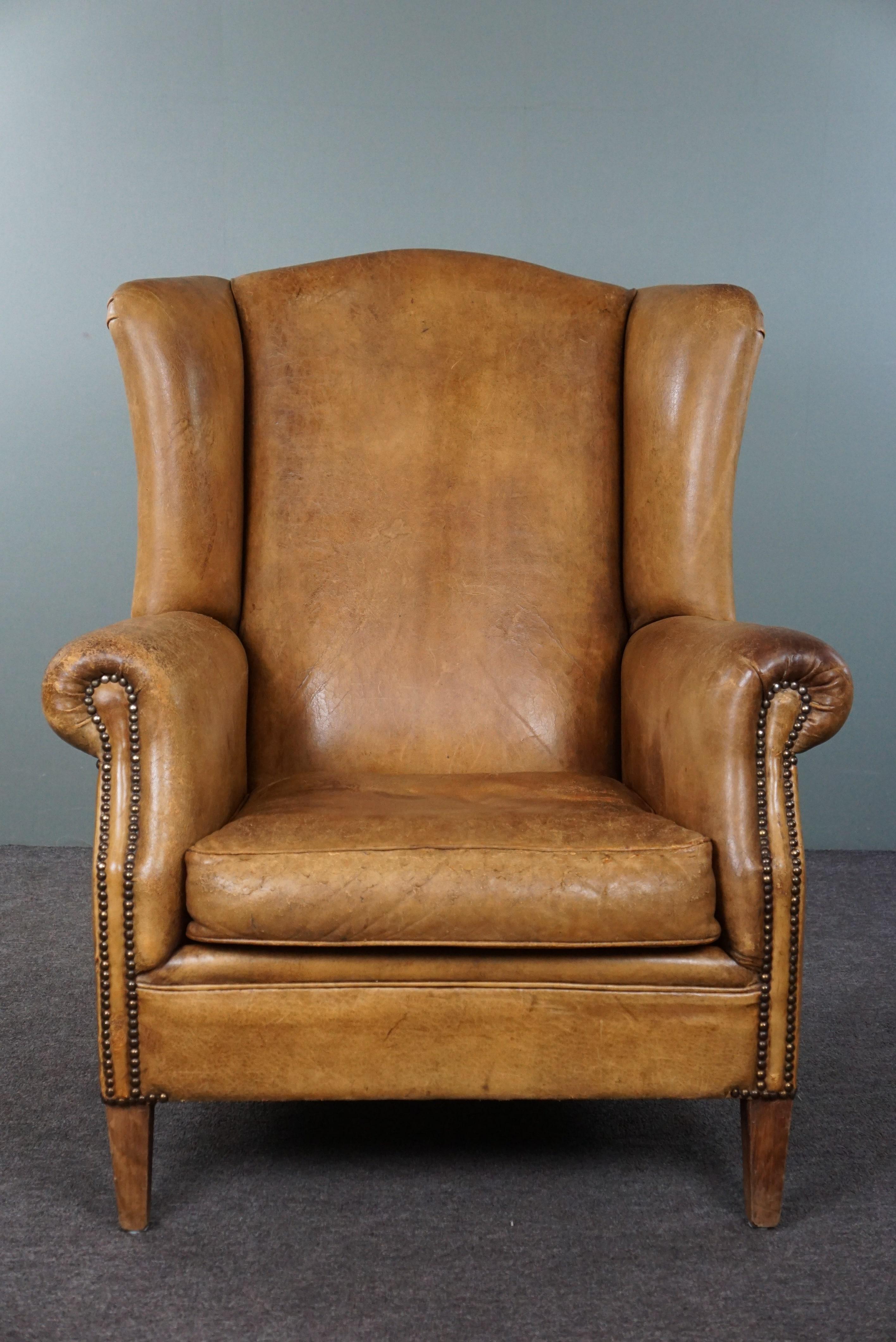 Offered is this perfectly worn-in, large sheepskin wingback chair in a light color. This beautiful, sizable wingback chair in a light cognac hue has an irresistibly lived-in appearance.
In typical English country-style interiors, you often see