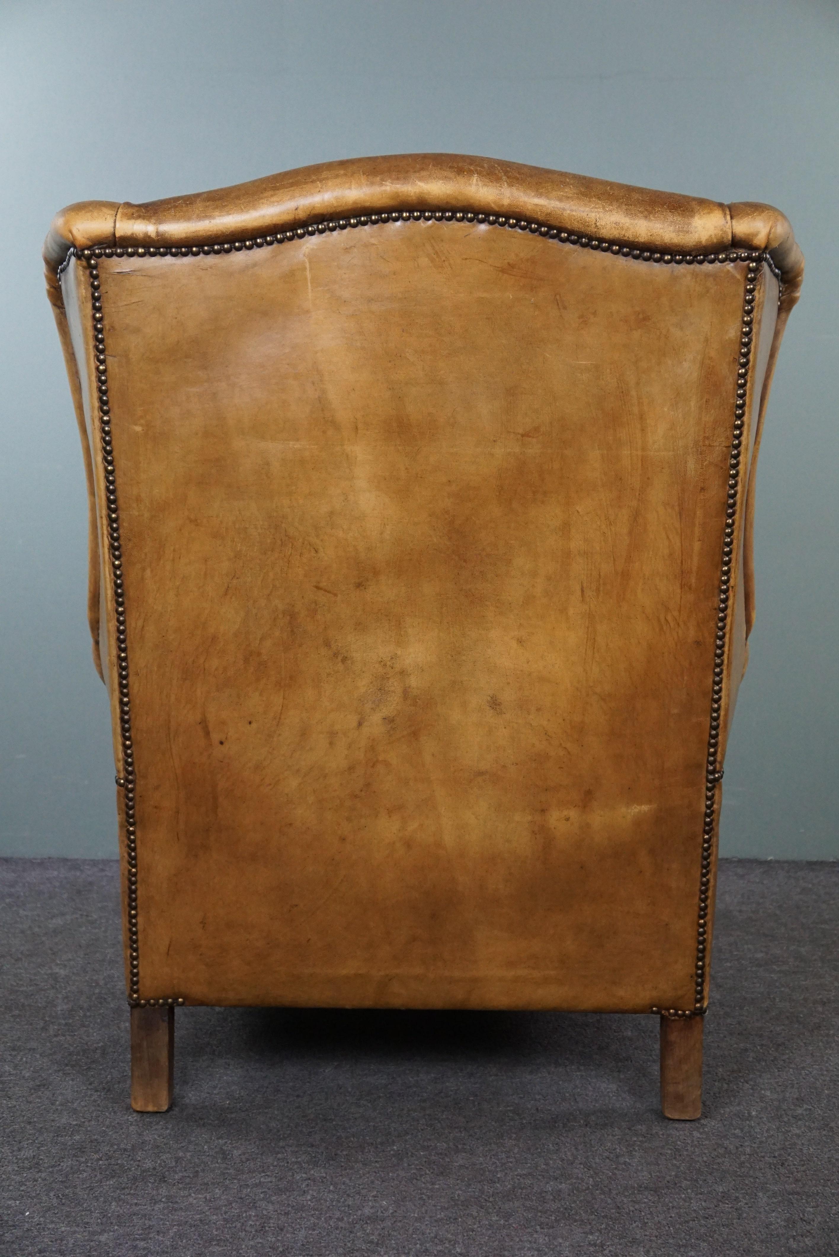 Late 20th Century Stylish, lived-in light-colored sheepskin wingback chair For Sale