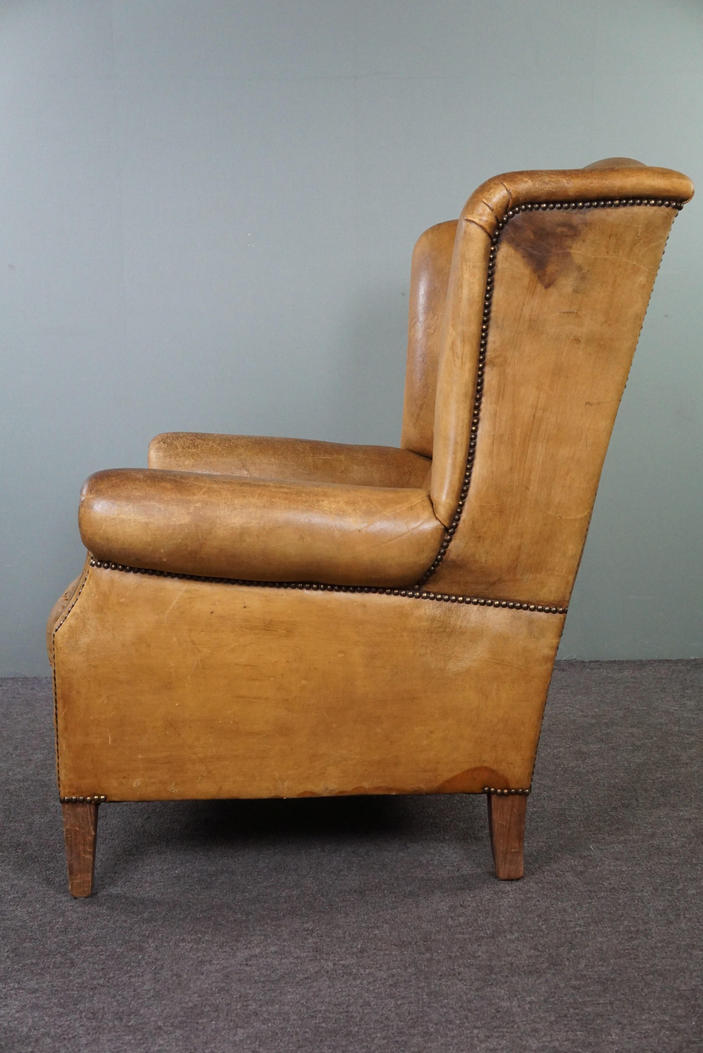 Leather Stylish, lived-in light-colored sheepskin wingback chair For Sale