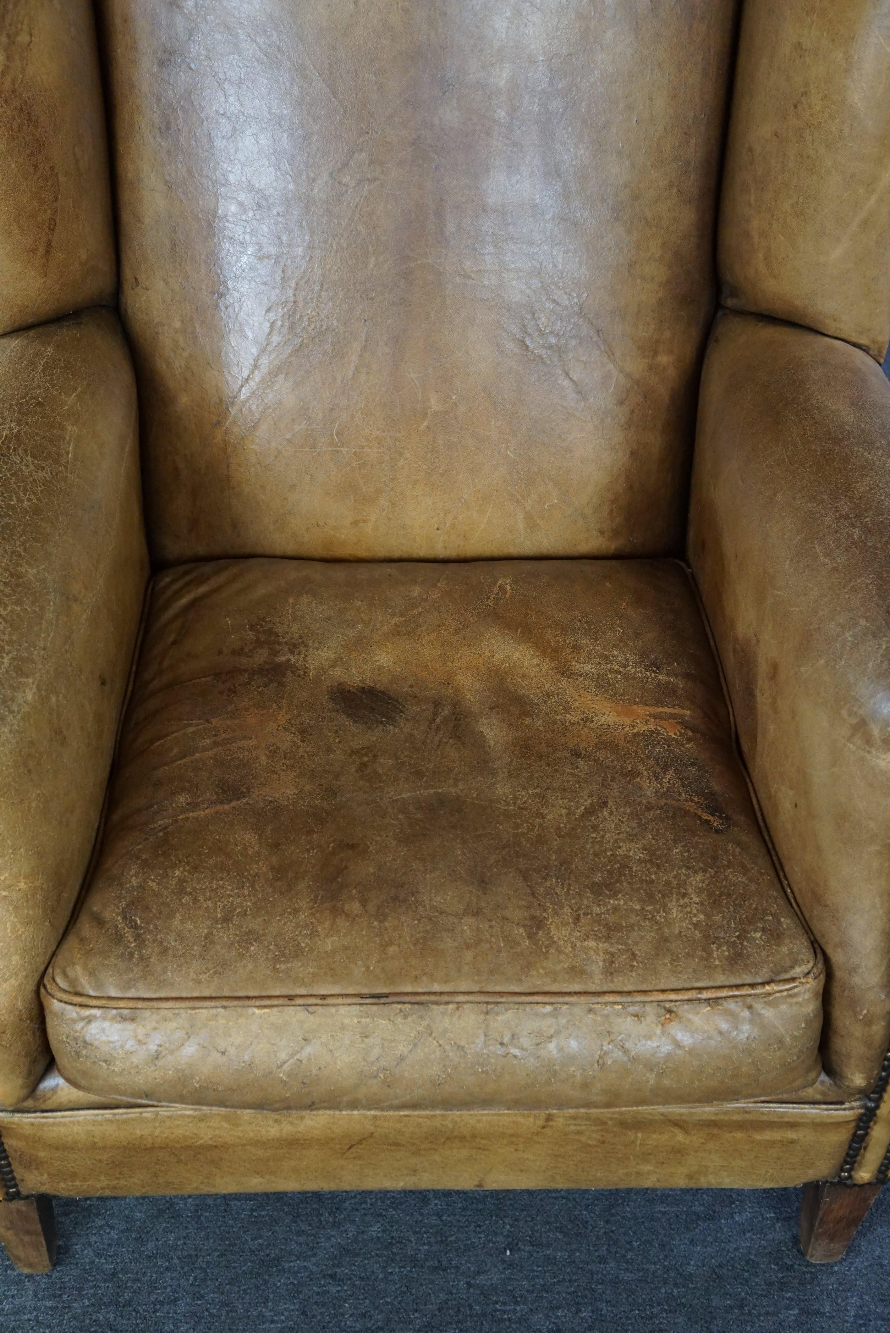 Stylish, lived-in light-colored sheepskin wingback chair For Sale 1