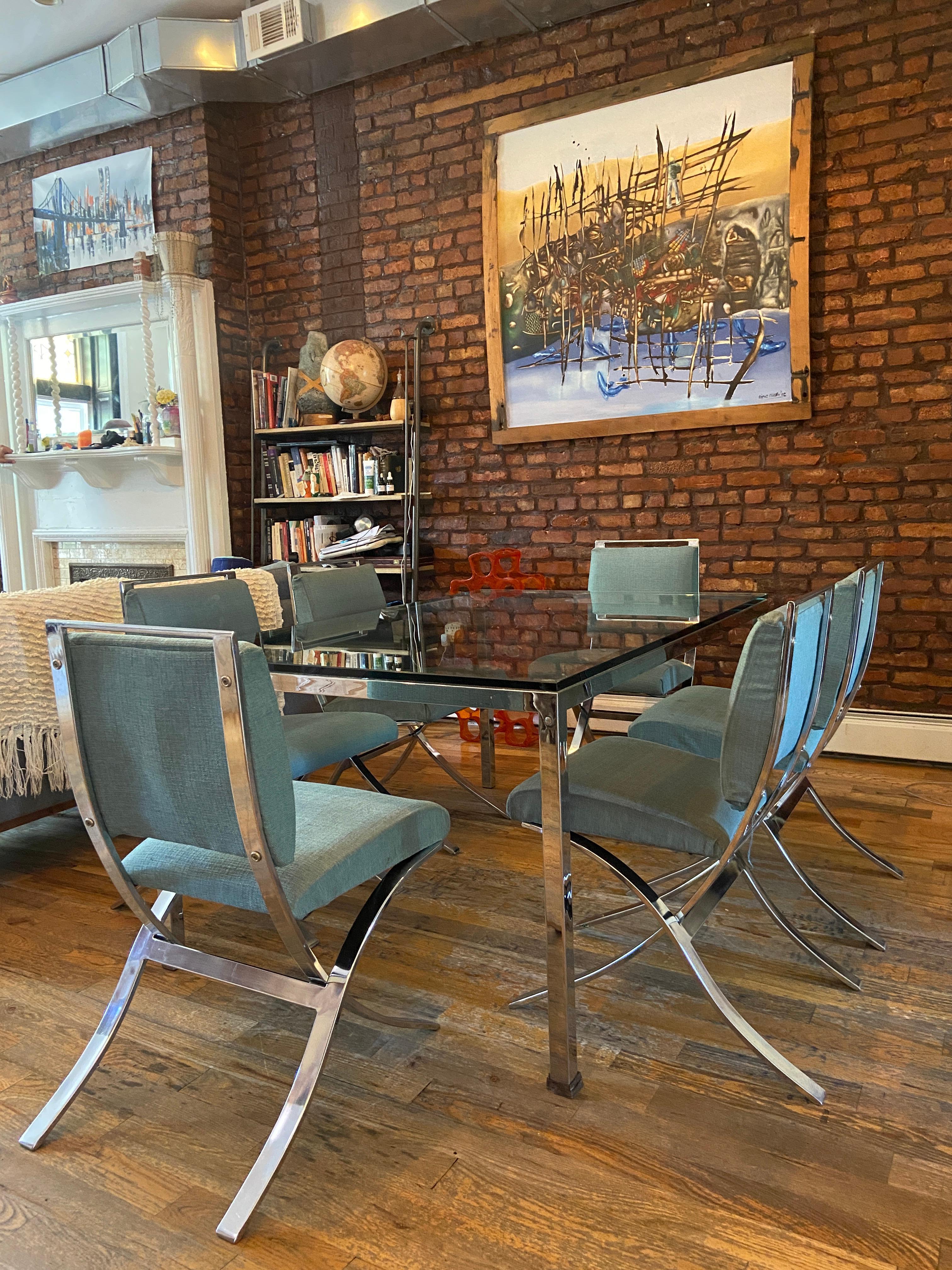 This is one stylish vintage chrome dining set. Includes six dining chairs with chrome frames and upholstered seats and backs, plus a matching chrome frame and glass top dining table. Making a beautiful Mid-Century Modern statement in any setting,