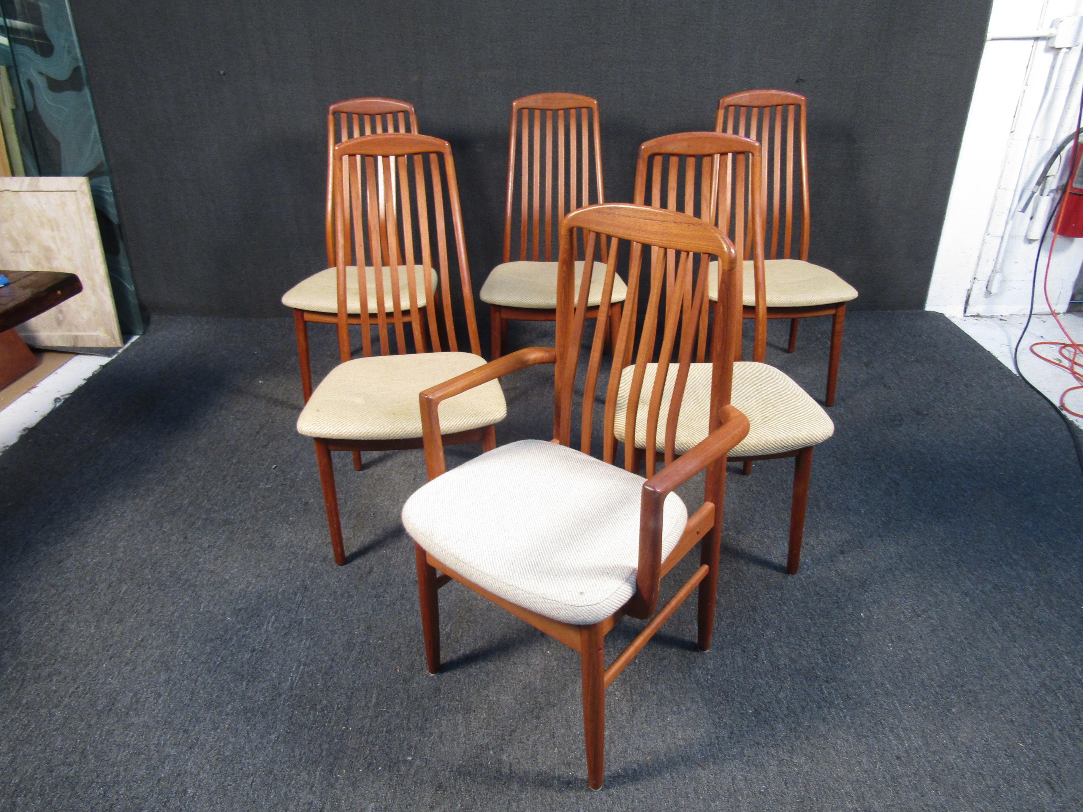 Stylish set of 6 Danish modern style dining chairs. One of the six chairs has interestingly sculpted armrests. Contoured backrests with vertical stretchers give these chairs a great look. Sure to make a great addition to any modern interior's decor.