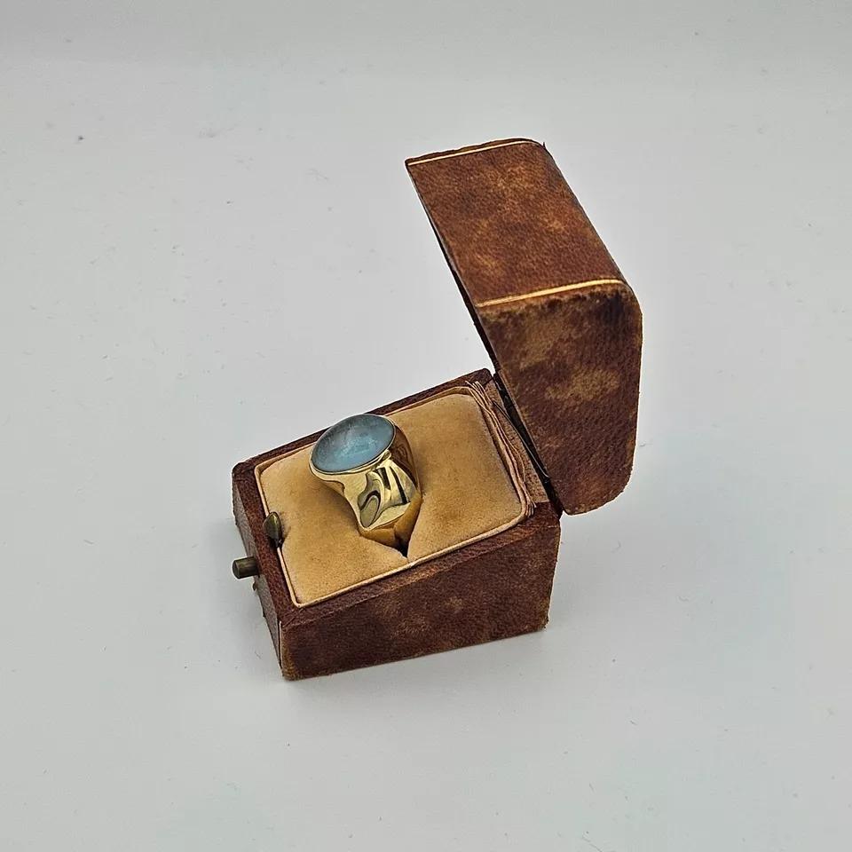 Italian 18kt yellow gold rubover set, single stone oval cabochon cut blue topaz ring. Topaz approximately 14mm x 9mm. Gross weight of ring: 8 grams.
Finger size: O. Wide plain, tapering hollowed shank.
No hallmarks, stamped 'Italy 750' 18kt