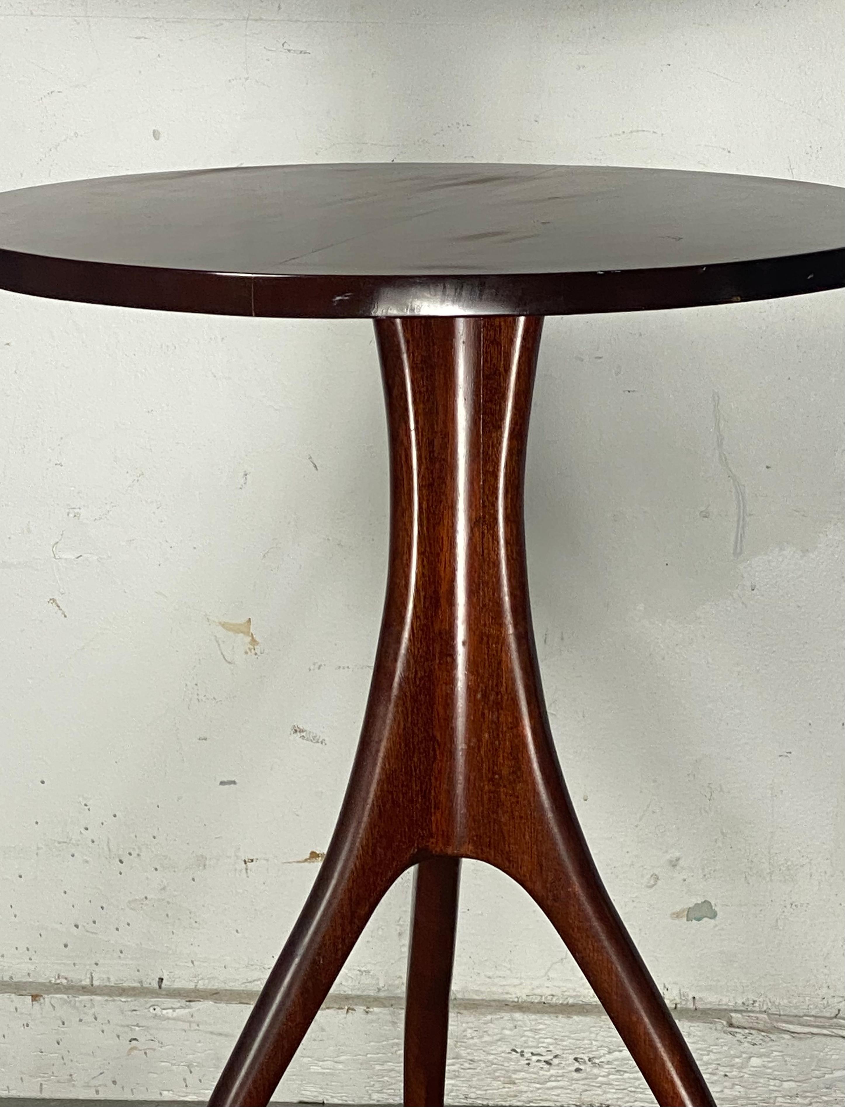Stunning side /lamp tripod table in mahogany attributed to Edward Wormley for Dunbar. Nice quality and construction. Wonderful style and design. Graceful splayed legs. Retains original finish. Patina. Minor scratch to top (see photo).