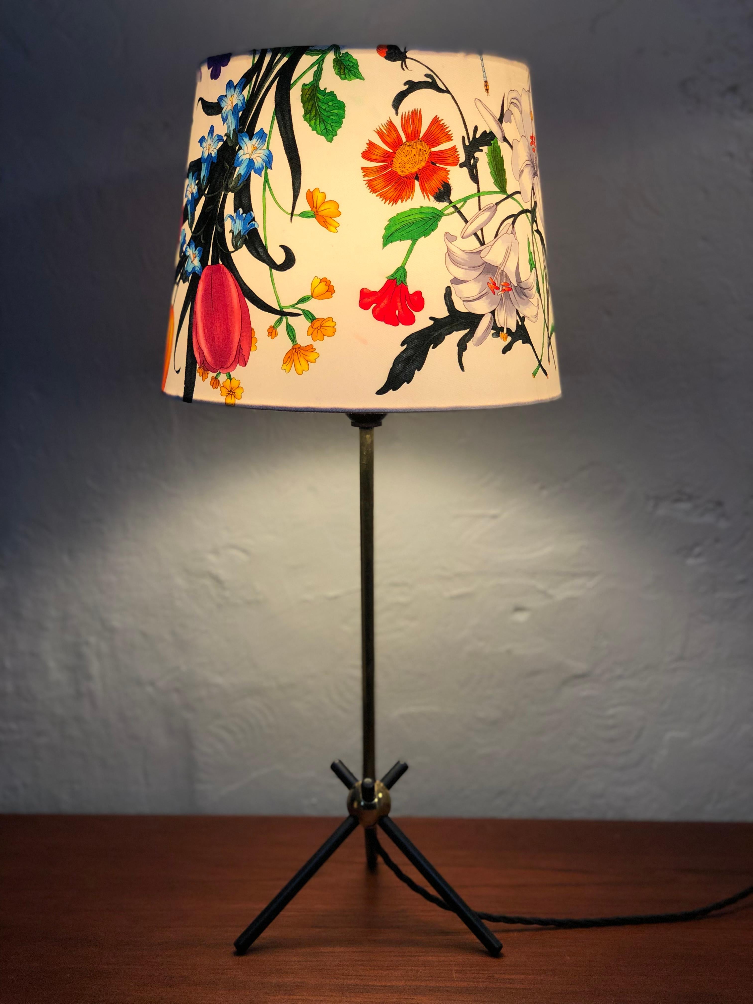 Vintage Mid-Century Modern table lamp with a very stylish period design. 
Three legged steel base attached to a brass stem. 
Rewired with a black twisted cloth flex and grounded.
Original Bakelite lamp holder with on off switch.
Original
