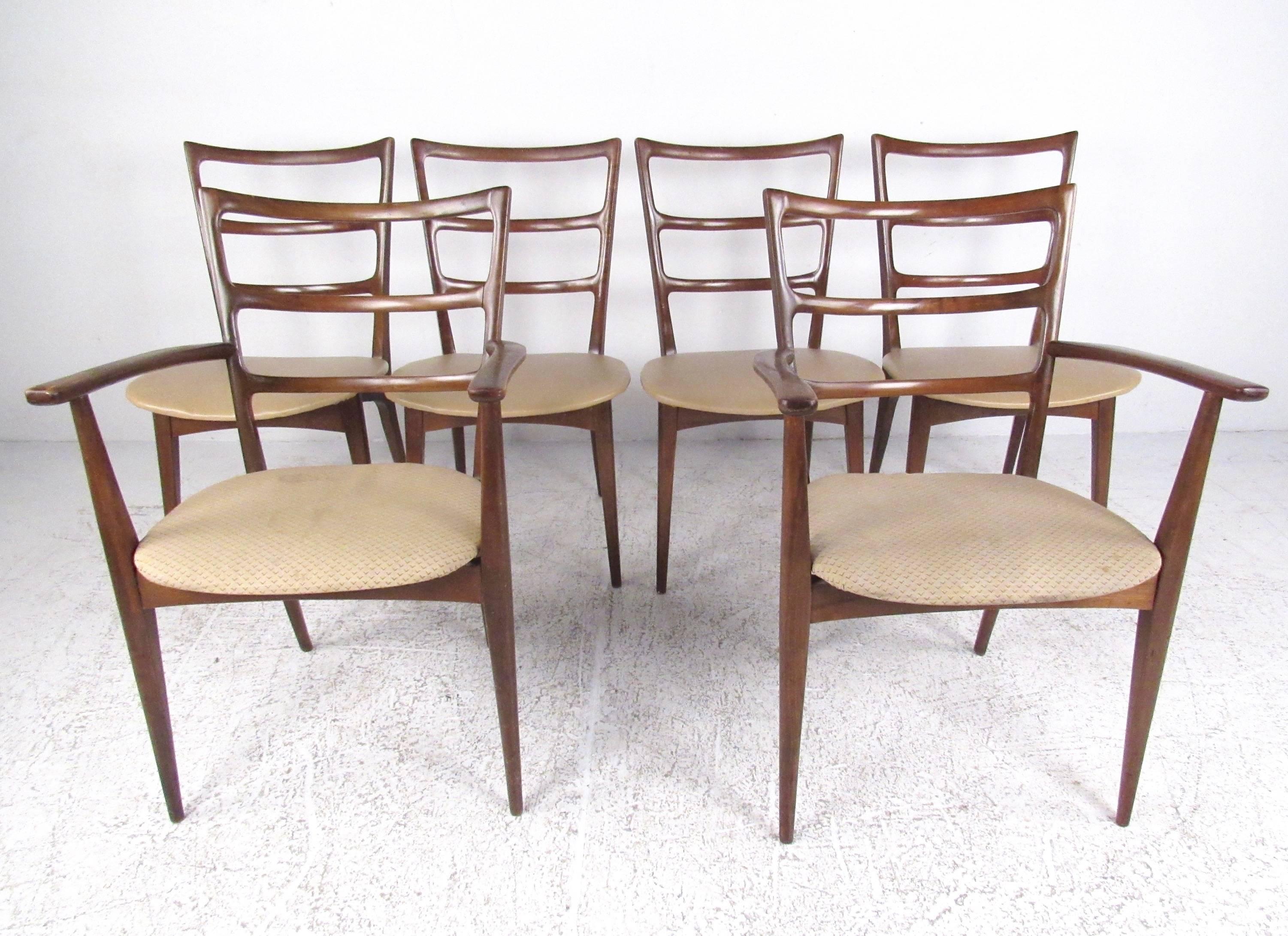 This stylish set of vintage modern dining chairs includes two armchairs and four side chairs. Sculpted high back seats, and comfortable padded seats add to the versatility and charm of the set. The perfect mix of impeccable midcentury design and
