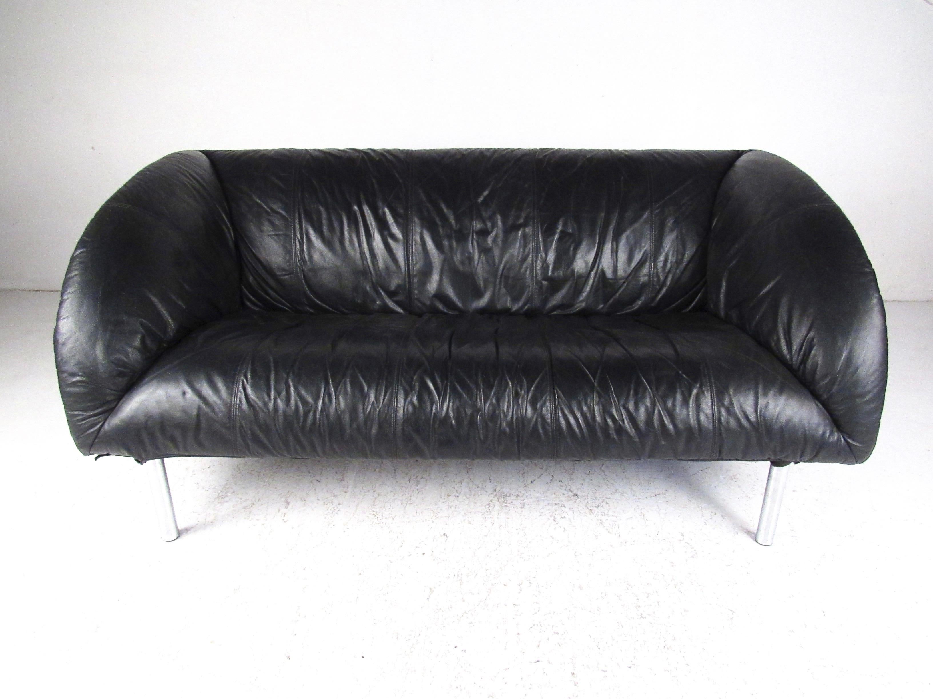 This comfortable modern sofa features shapely two seat design with black leather upholstery. Chrome legs add to the modern appeal and mid-century style of this sofa, perfect seating for home, office, or business arrangement. Please confirm item