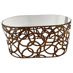 Table basse oblongue élégante avec plateau en miroir et base à motif circulaire en laiton