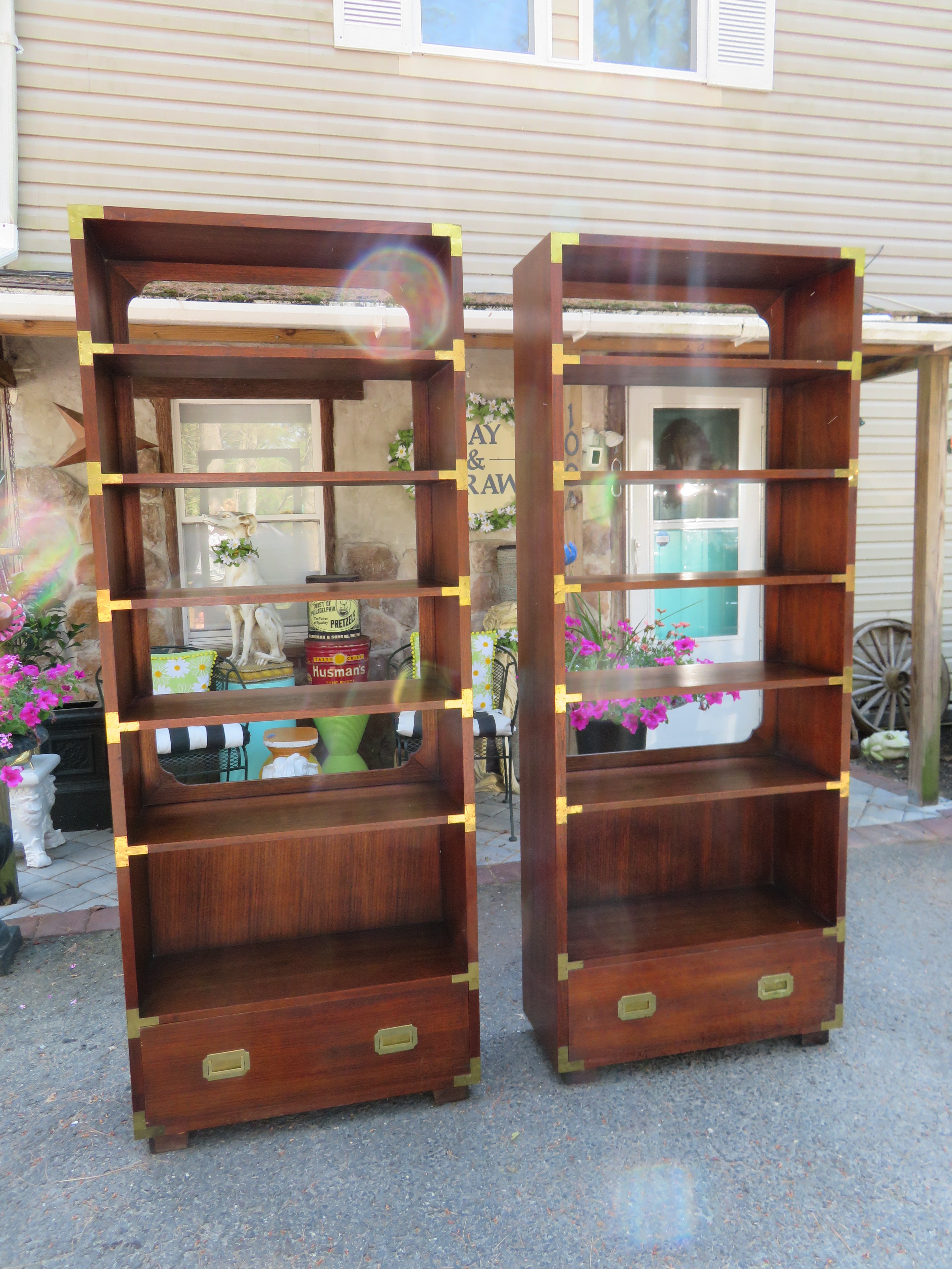 Stylish pair of walnut Dixie Campaign style etagere bookcases. We love that these are double-sided so they can be used floating in the middle of your space. They measure 77