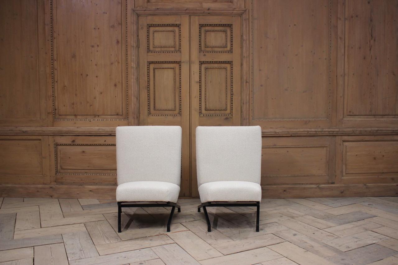 A very stylish pair of circa 1950s French armchairs, with a very striking design, having been reupholstered by us in a wool and linen fabric. 
This elegant and chic pair of chairs will work well in a contemporary setting.