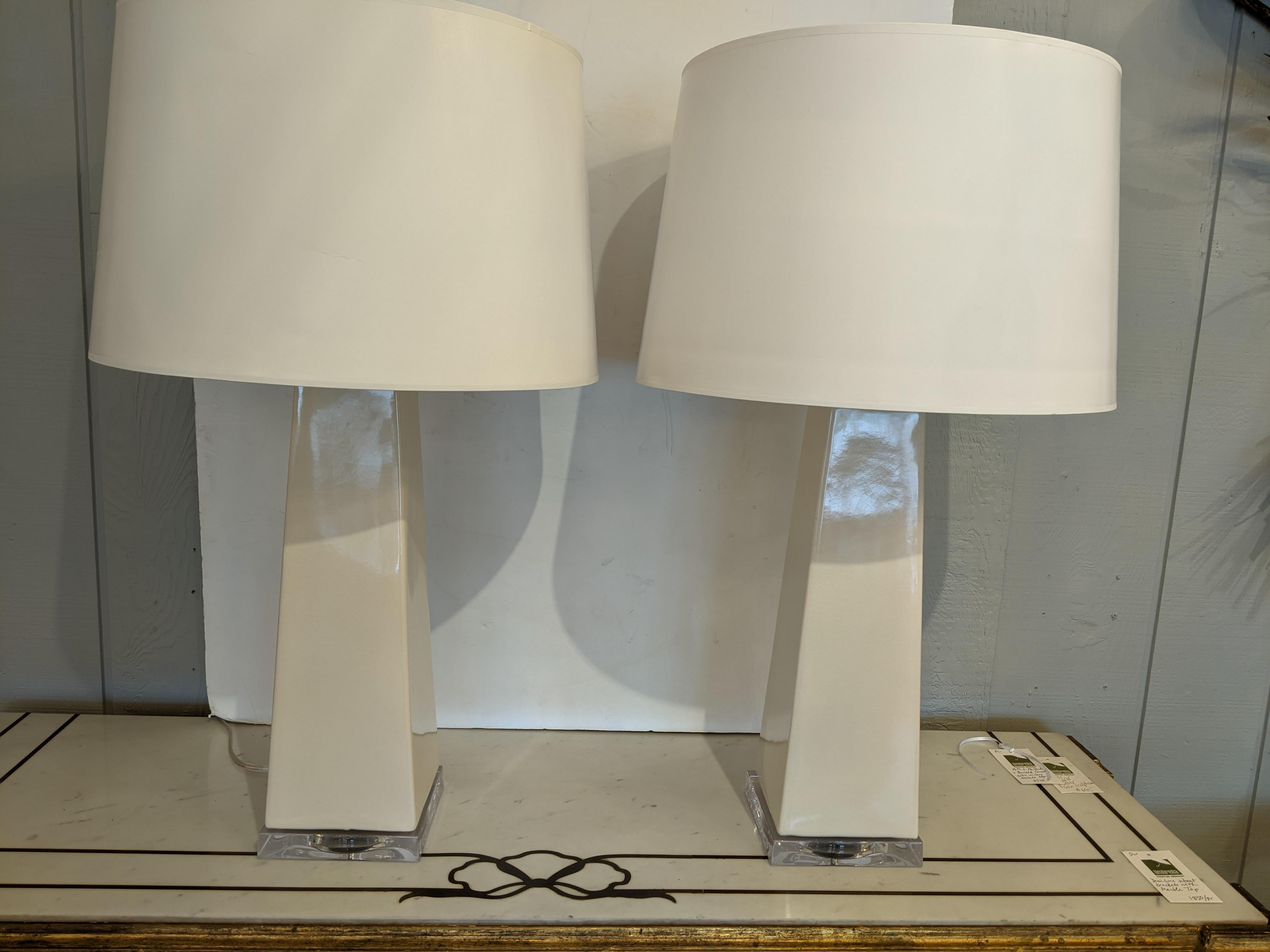 Statuesque pair of contemporary cream composition or ceramic glazed lamps on lucite bases. Includes shades.
6 x 6 base Shade is 14.5 diameter.