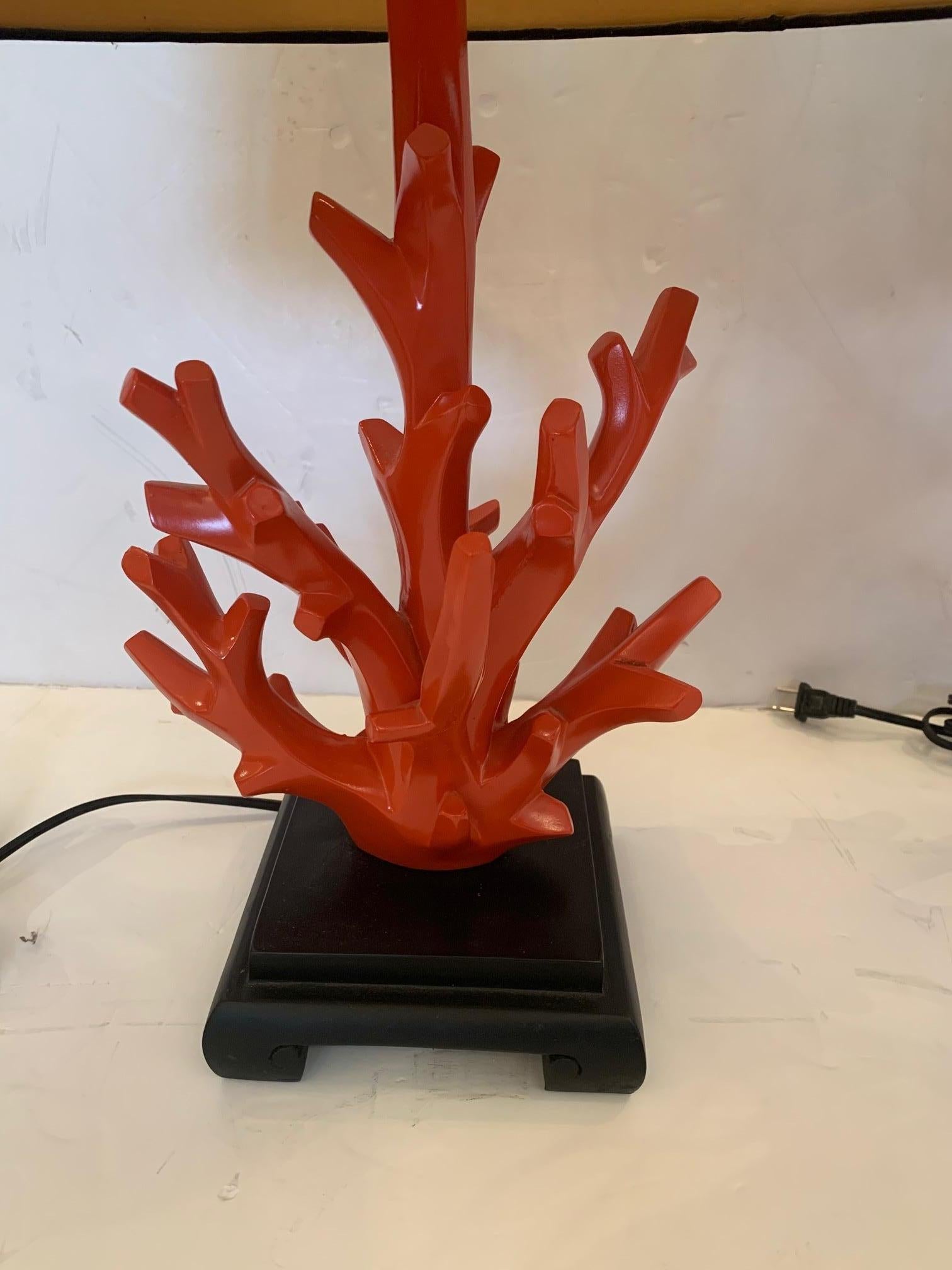 A striking pair of Hermès orange faux coral table lamps with black bases and shades. The orange faux coral finials are a nice touch.
Measures: 26.25” H to finial.
 
 