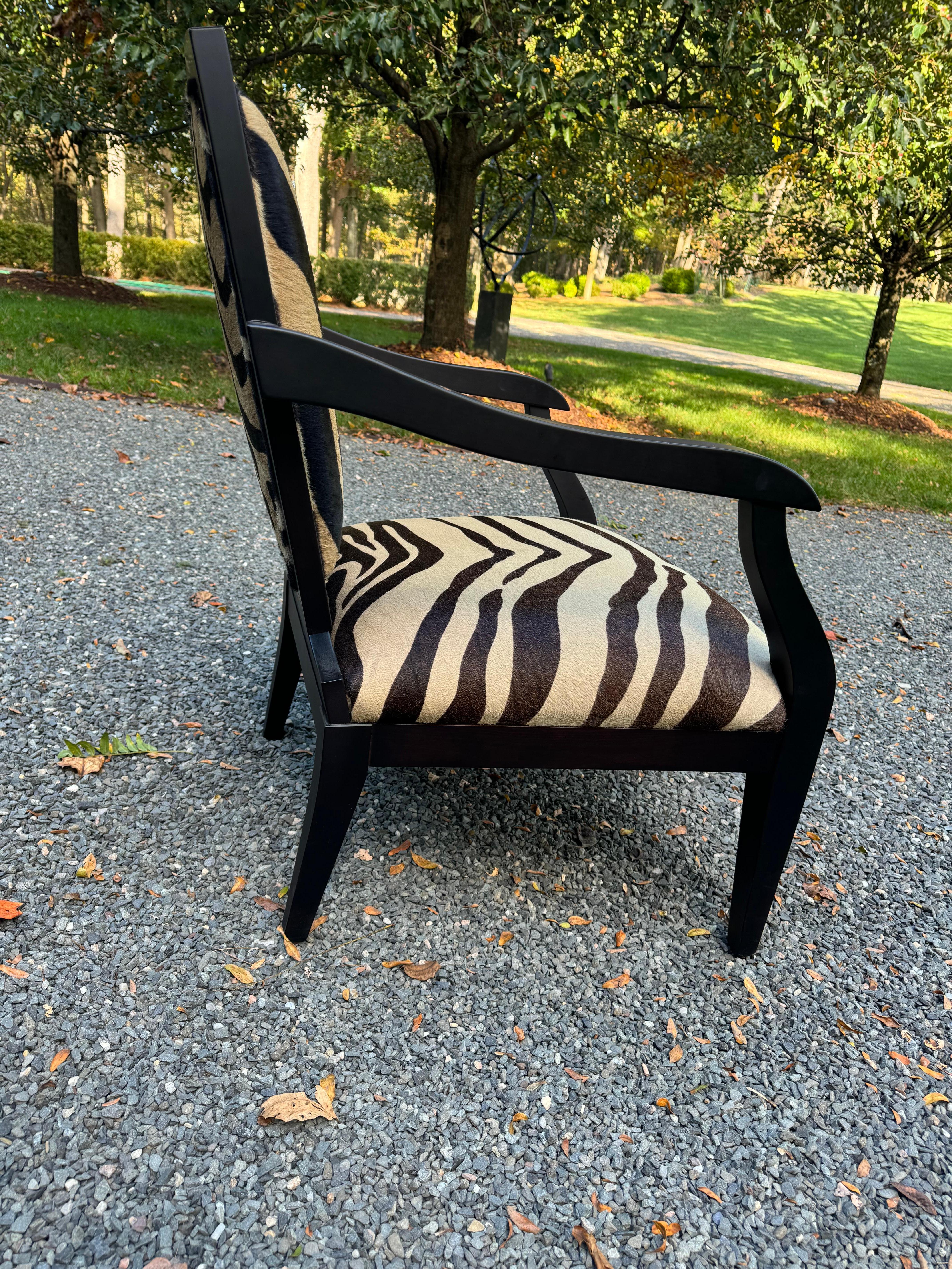 Stylish pair of black finished wood framed armchairs with chic zebra pattern cowhide upholstery to the seat, seat back and on verso of the seat backs.  Made by high end retailer in Venice Italy.  Smania.  
arm height 25