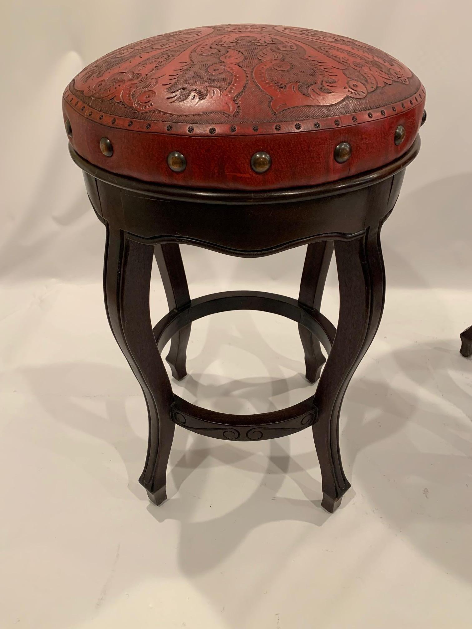 Rich Italian embossed leather bar stools in a marvelous orange red color, having large copper nail heads embellishing the periphery. Solid walnut bases.