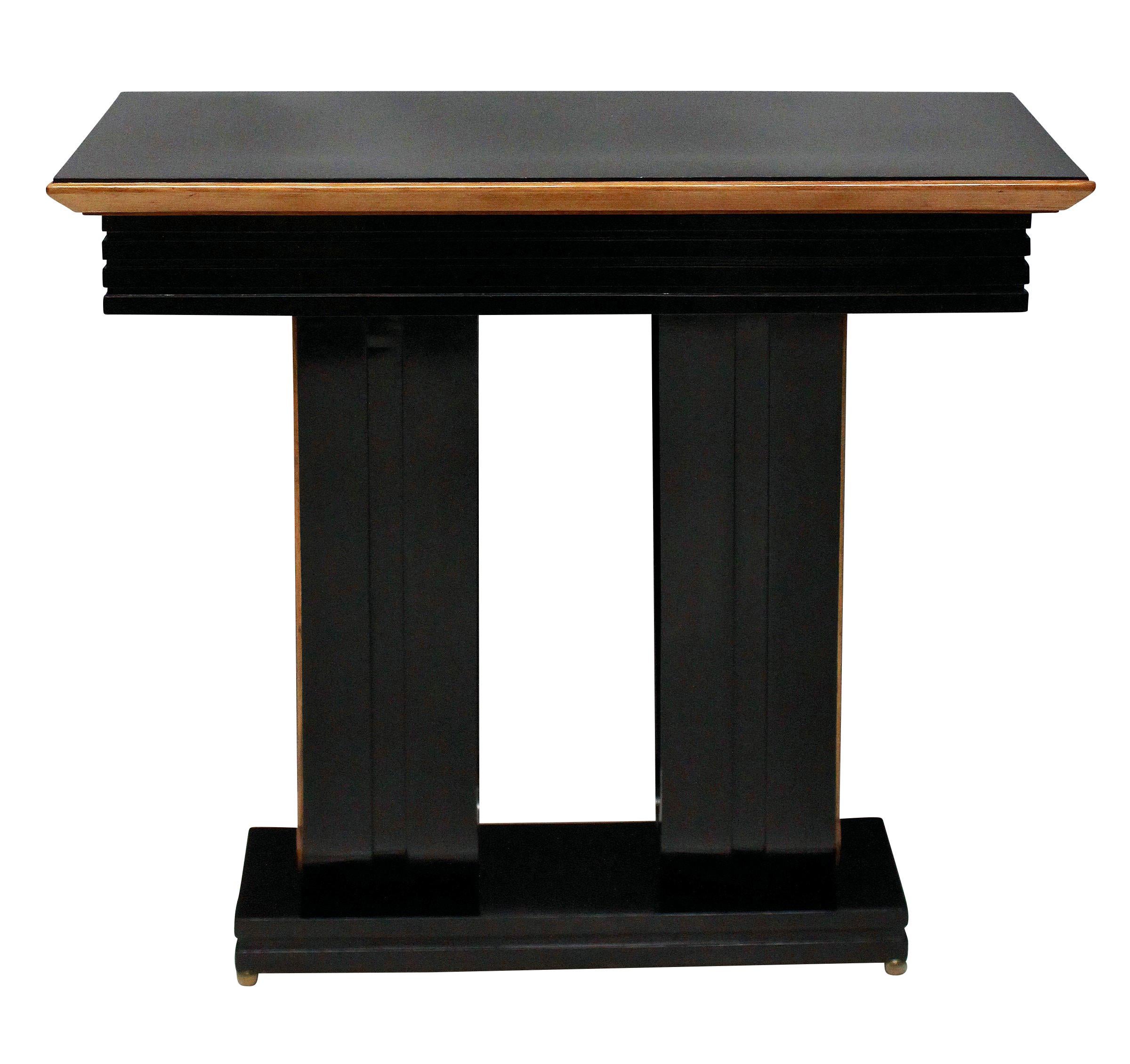 A pair of stylish Italian ebonized console tables, with lemon wood detailing and on brass ball feet.