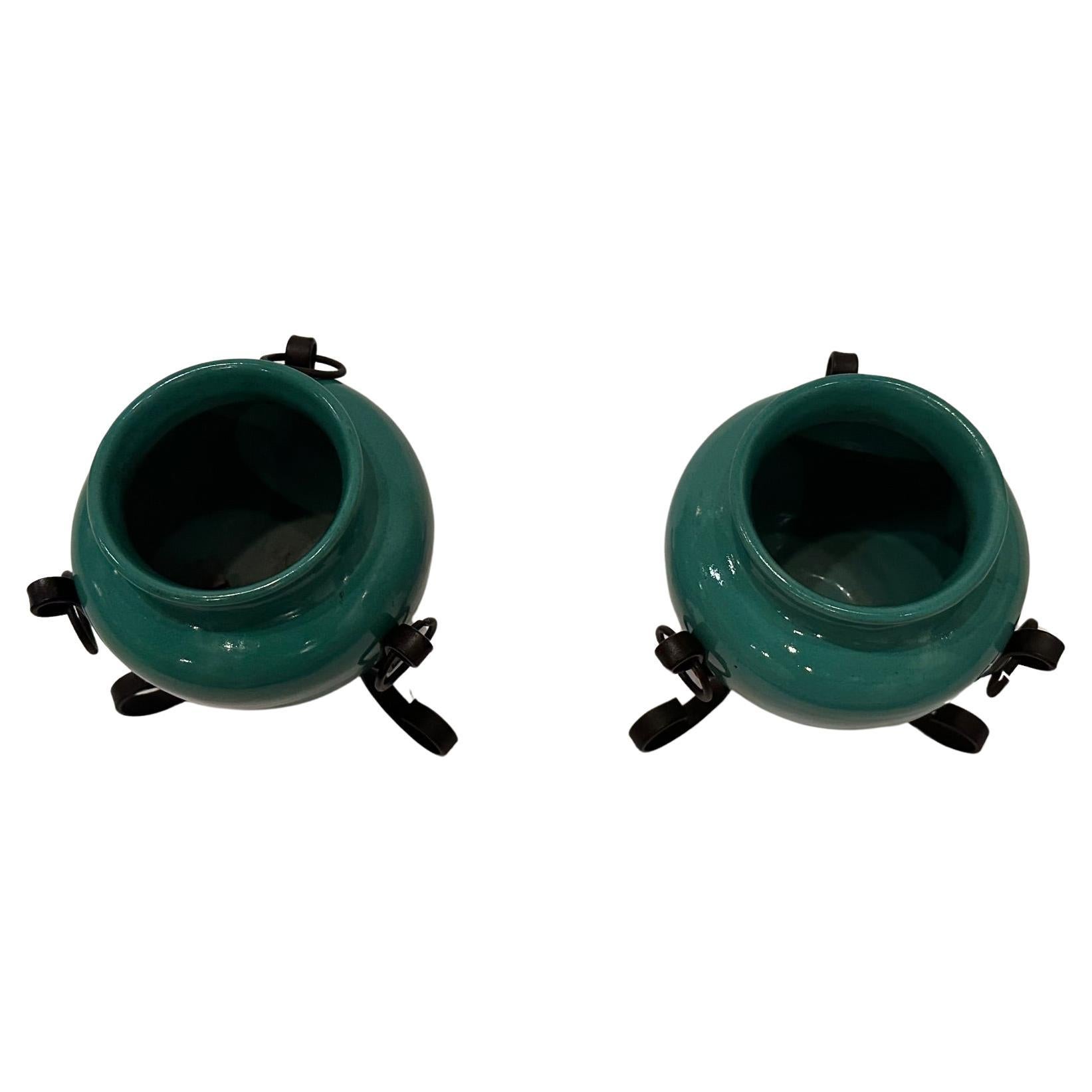 Stylish set of celadon green Italian pottery vases that sit in hand wrought iron black stands.  opening 2.75