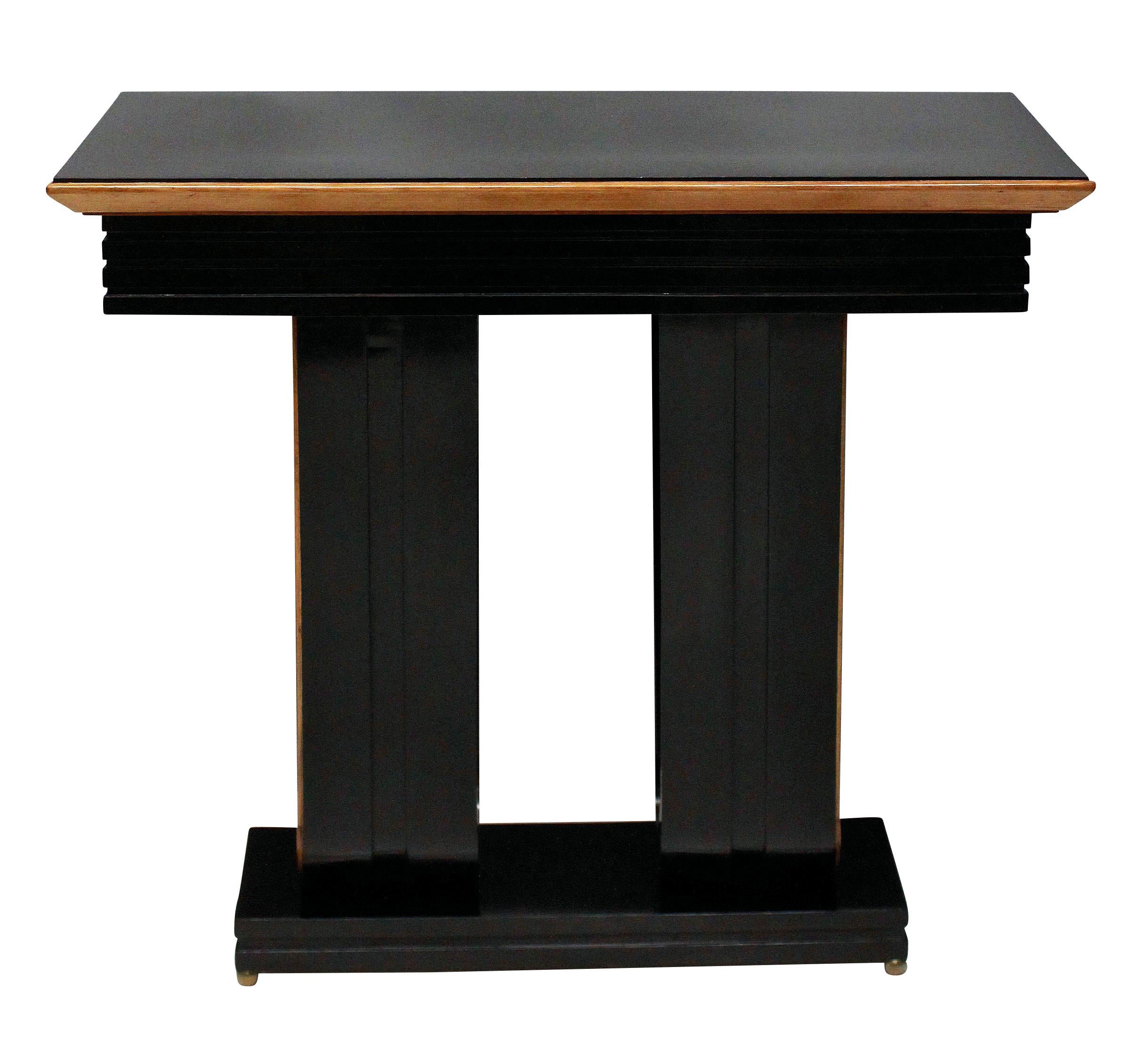 A pair of stylish Italian ebonized console tables with lemon wood detailing and on brass ball feet.