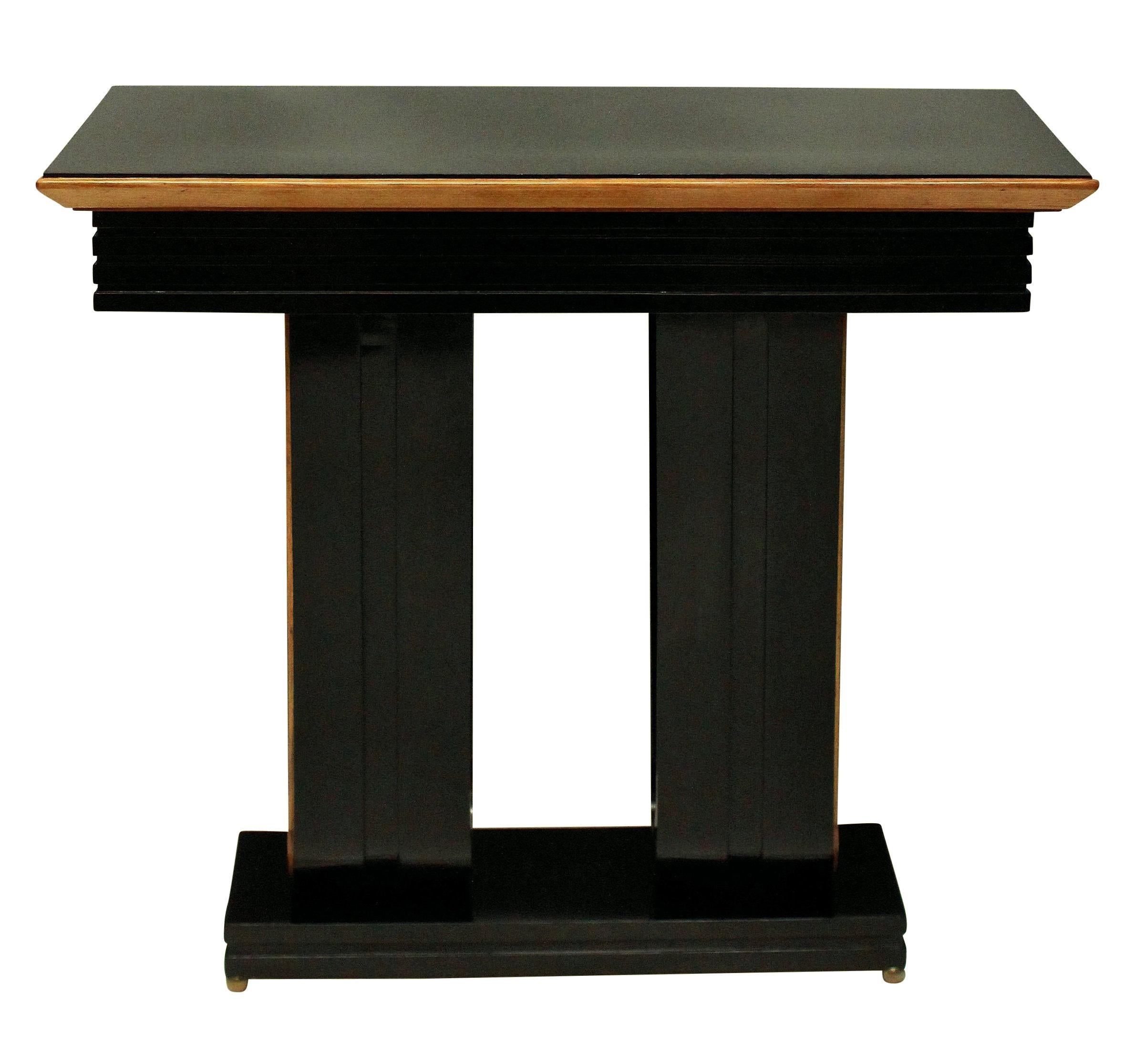 A pair of stylish Italian ebonized console tables with lemon wood detailing and on brass ball feet.