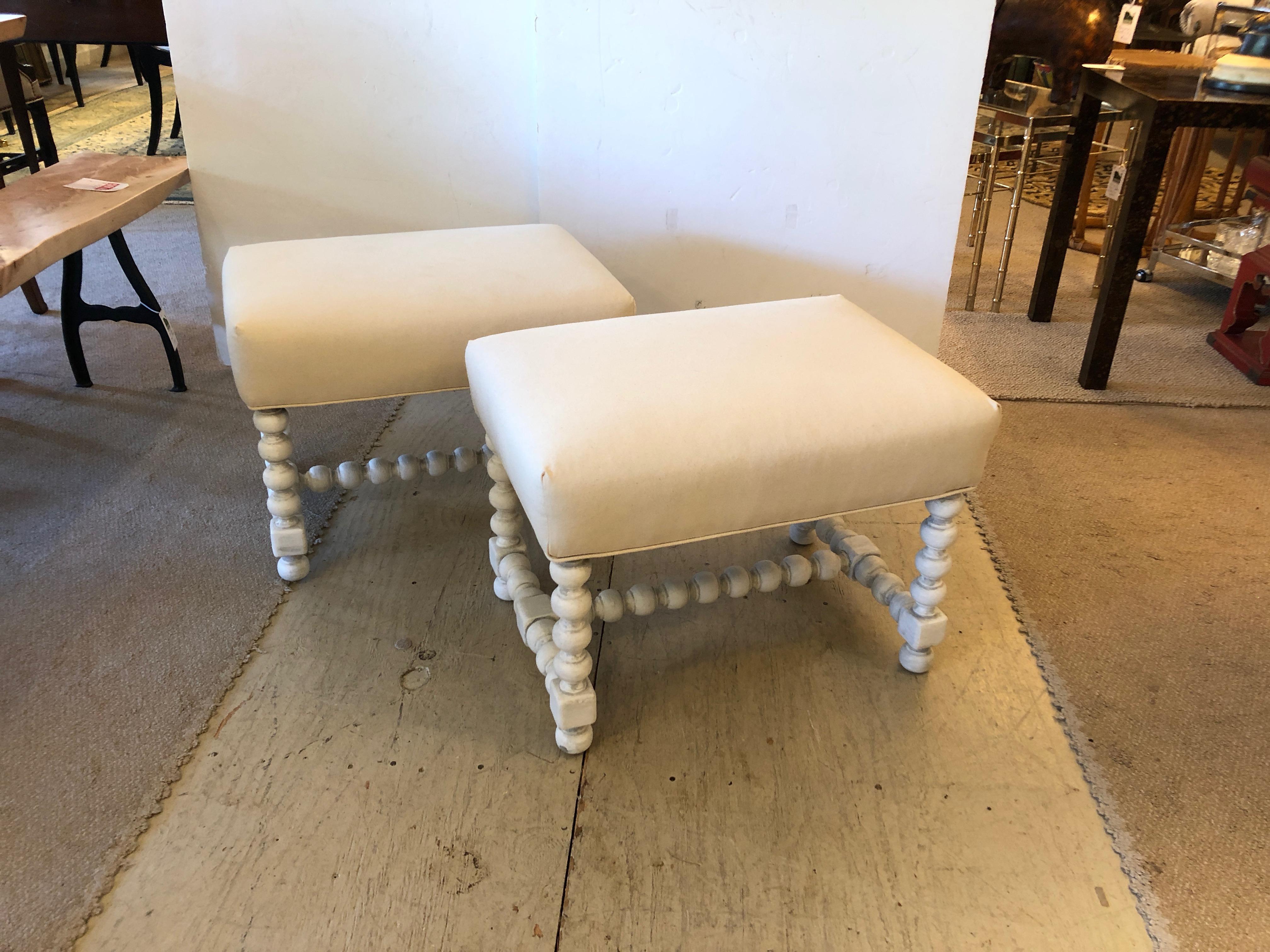 Two neutral and stylish ottomans or benches having grey painted turned wood barley twisty
bases and white duck upholstered tops.