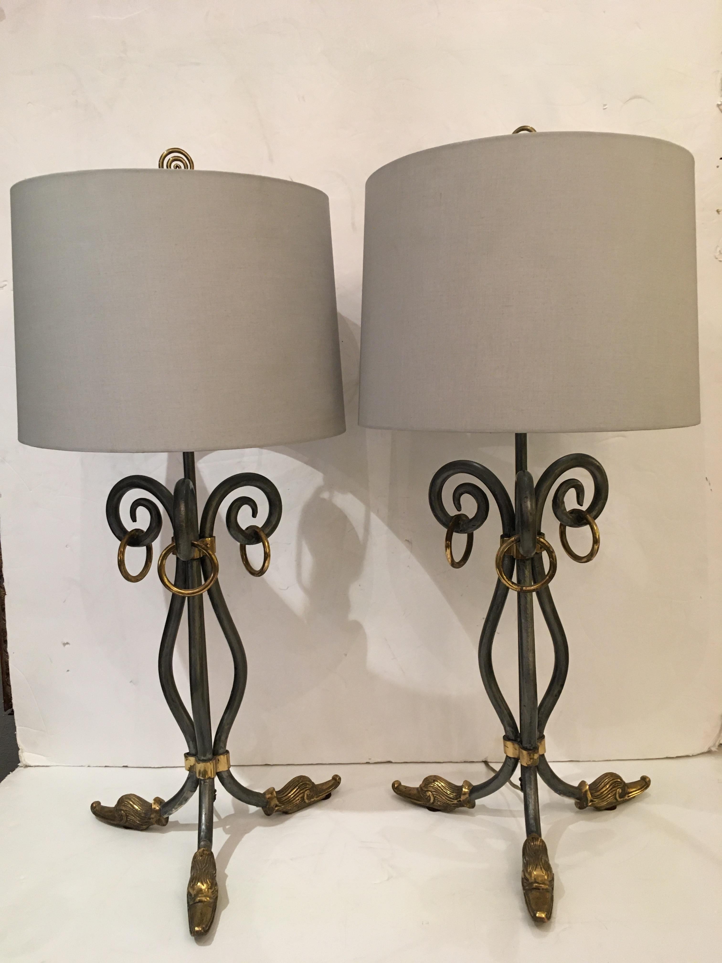 Stylish and fun pair of silver iron table lamps having brass embellishments including fabulous duck feet and ring handles. The spiral finals add a finishing touch.