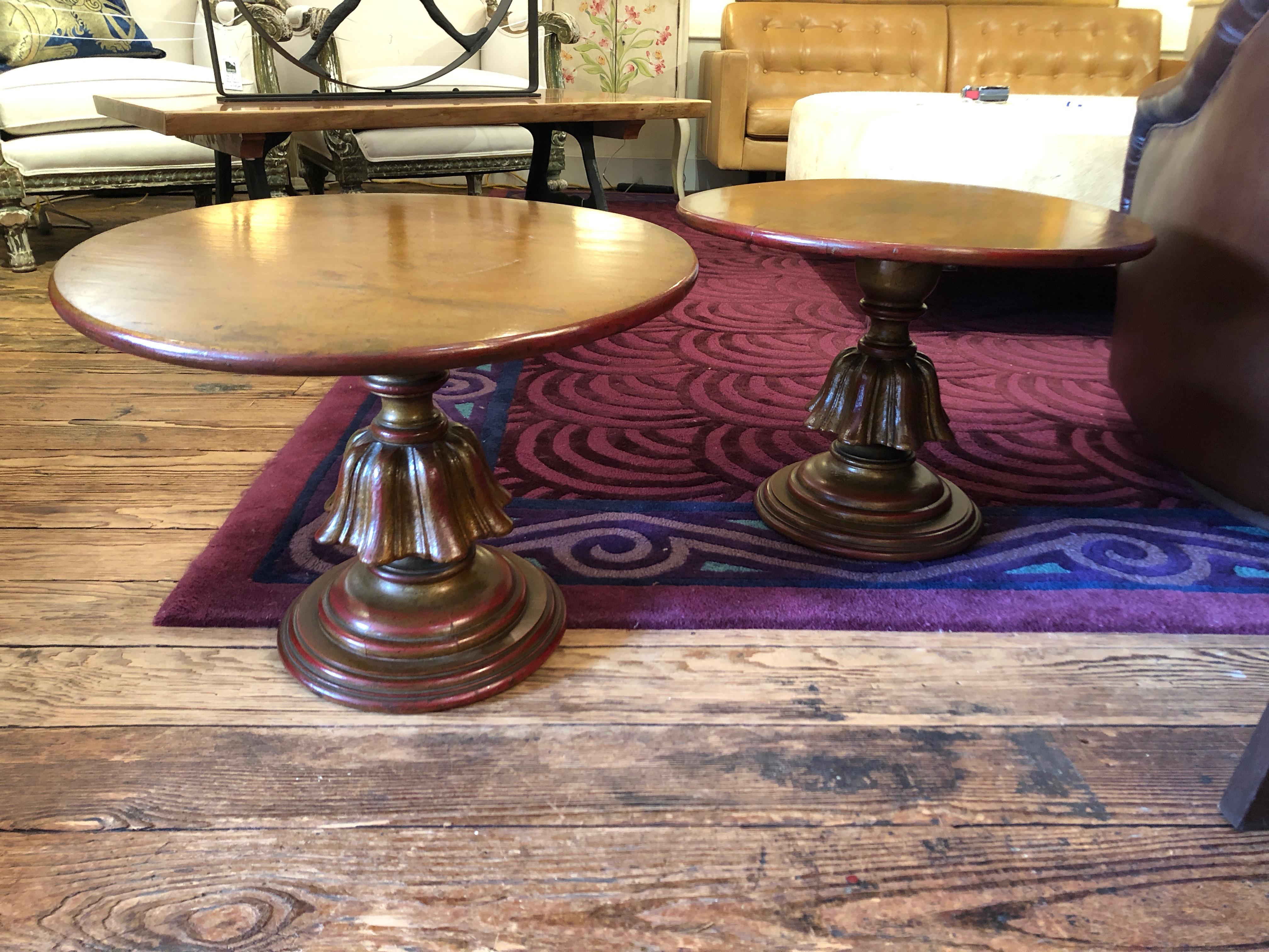 Great looking round end tables in a perfect 22 diameter size, having a wonderful gilded patina with warm red paint undertones. The pedestal bases are simple yet glamorous carved wood with a neoclassical bent.