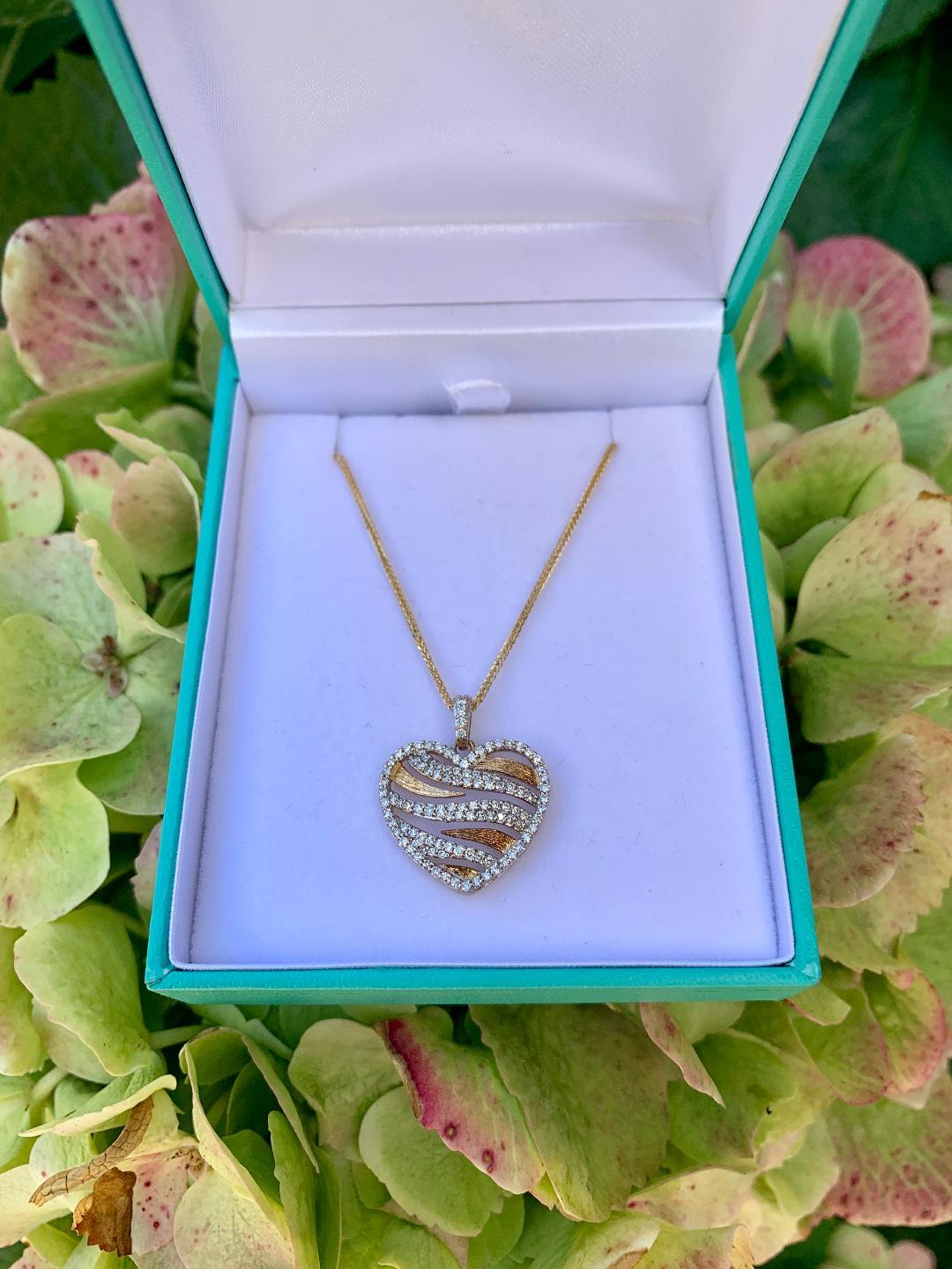 Very stylish, 14 karat yellow gold micro pave diamond heart pendant with diamond bale created in a fun and very fashionable zebra stripe design. Yellow gold stripes are a Florentine finish to create a rich contrast. Pendant features 108 round