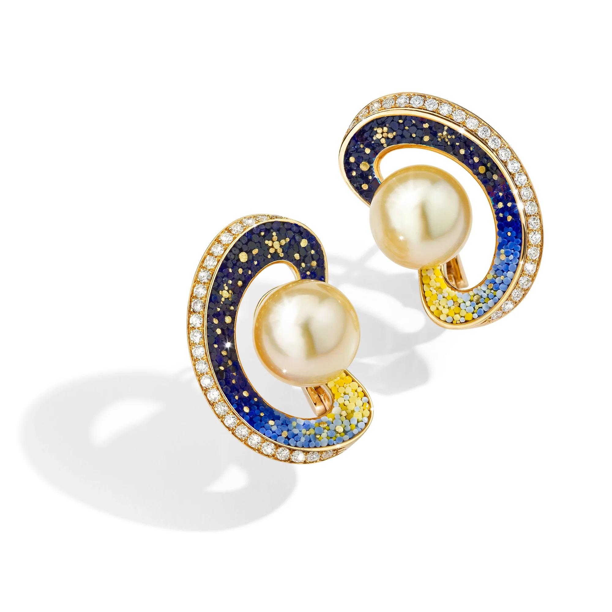 The Saturno earrings will take you into a celestial escape. 
A mesmerizing South Sea Gold Pearl lies in the center of each piece, encircled by a mesmerizing ring filled with intricate blue and yellow micromosaics, evoking the cosmic beauty of a