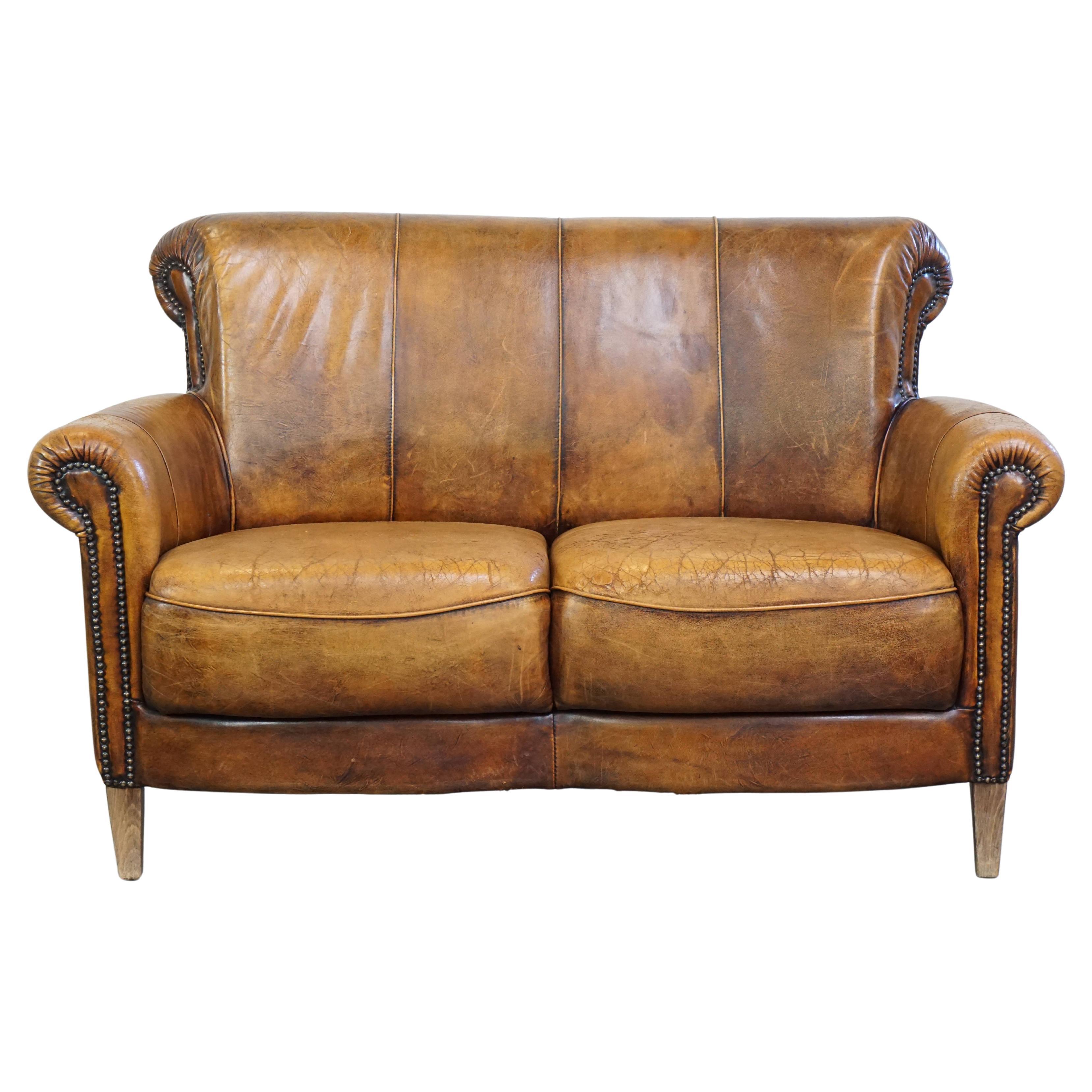 Stylish positively worn vintage sheepskin 2-seater sofa with comfortable seating