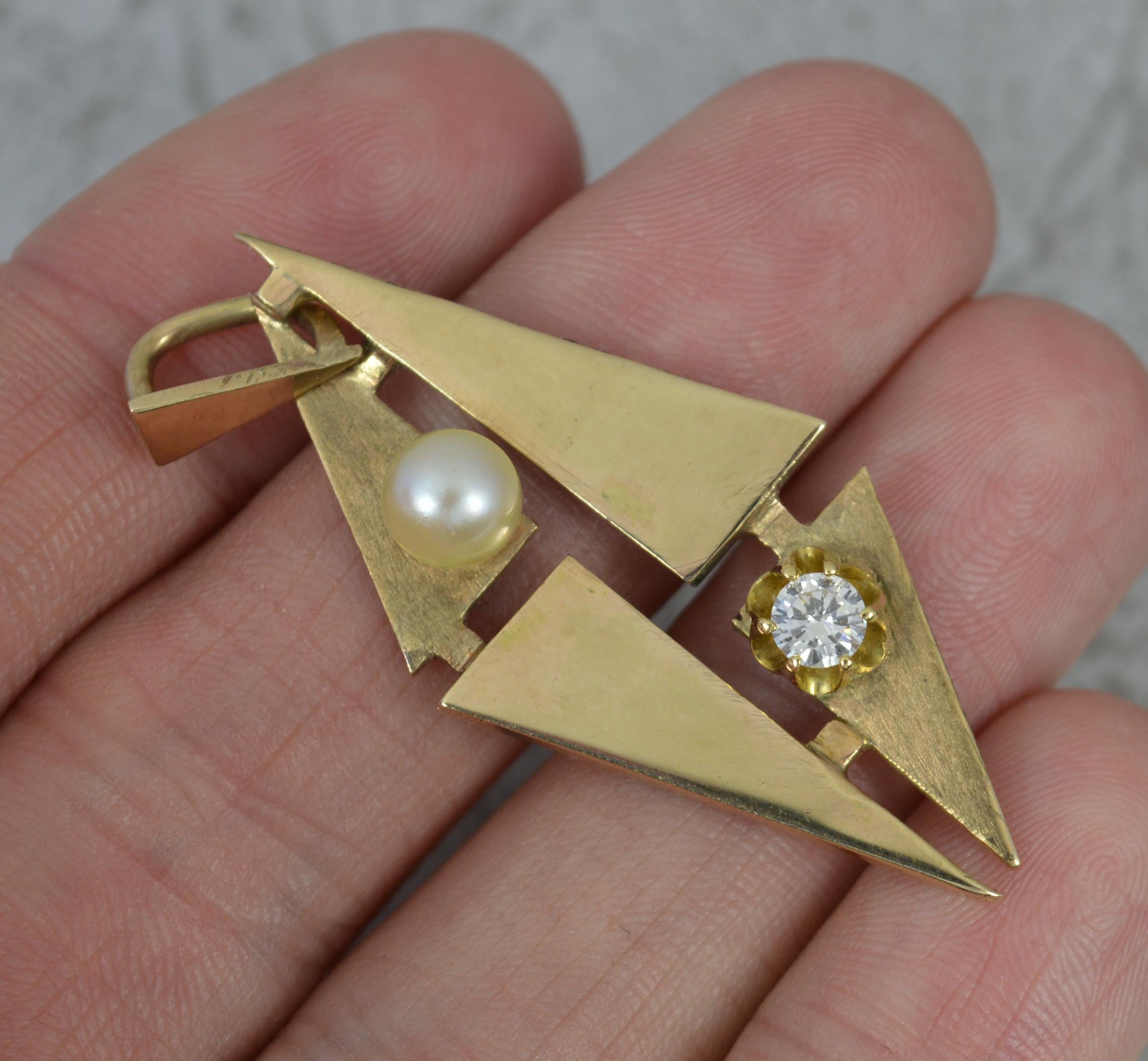 A stunning retro pendant.
Solid 9 carat yellow gold example.
A highly unusual triangular abstract shape. The plain panels of smoot polished finish with a brushed finish to the sections set with a single pearl and diamond. 0.25ct stone, vs clarity,