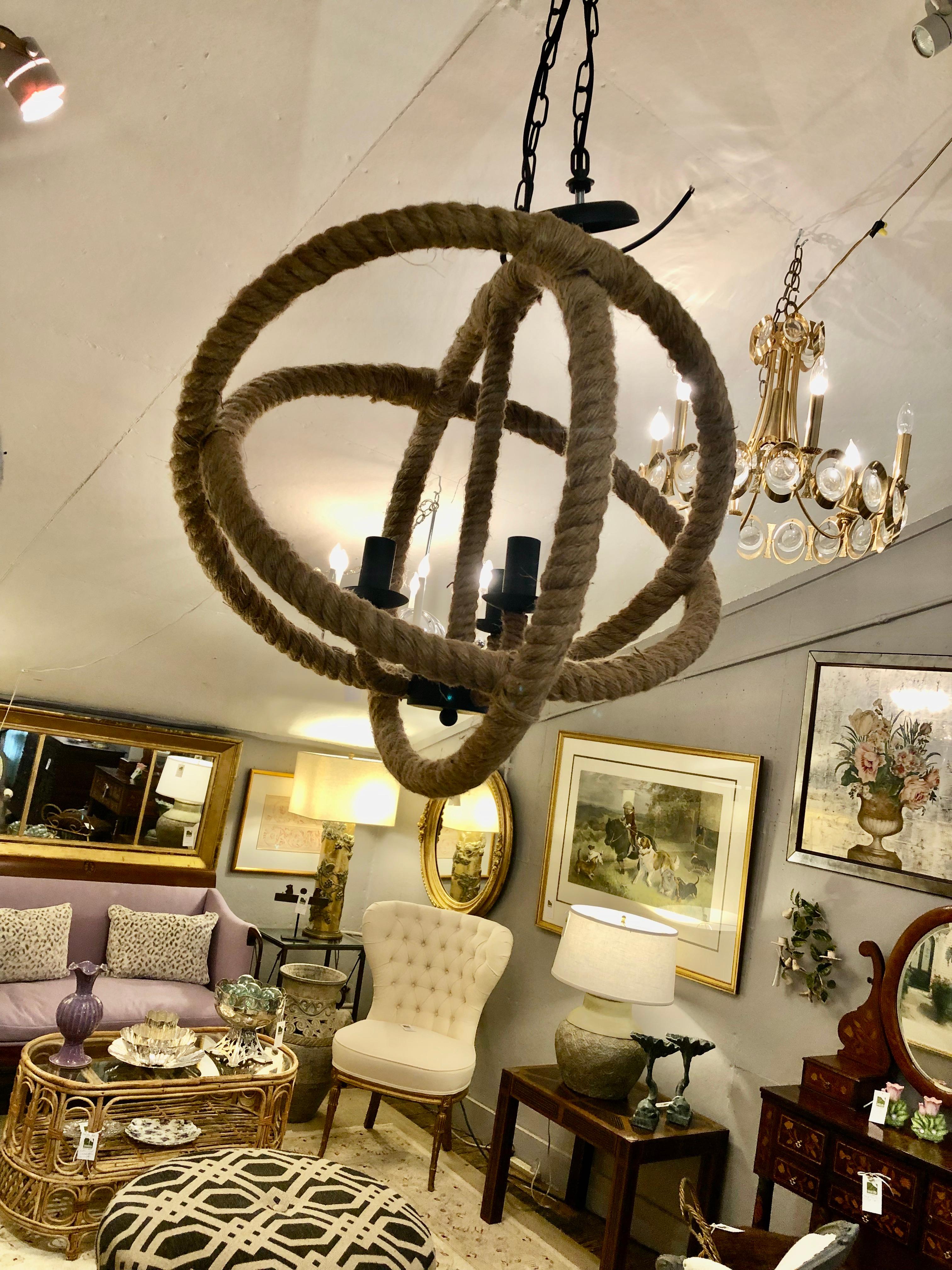 Great looking round armillary style chandelier wrapped in handsome rope with central 3 arm fixture in black iron.
Comes with original ceiling cap and 3 ft of chain.
