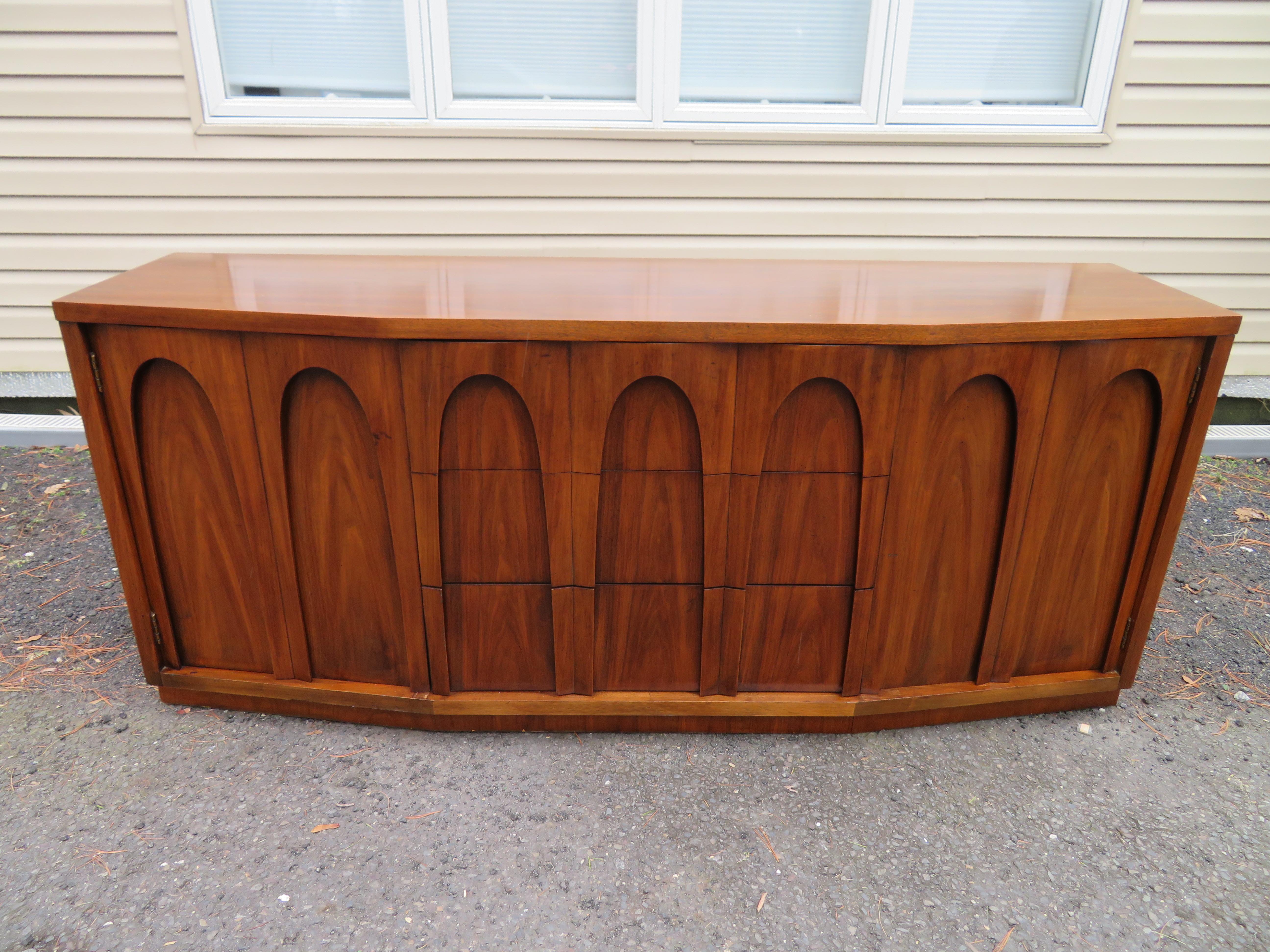 Stylish sculptural front walnut Brasilia style buffet credenza. We just love the quality and craftsmanship of this piece, they surely don't make them this anymore! The top middle drawer has lovely dividers to keep your silverware organized and tidy.