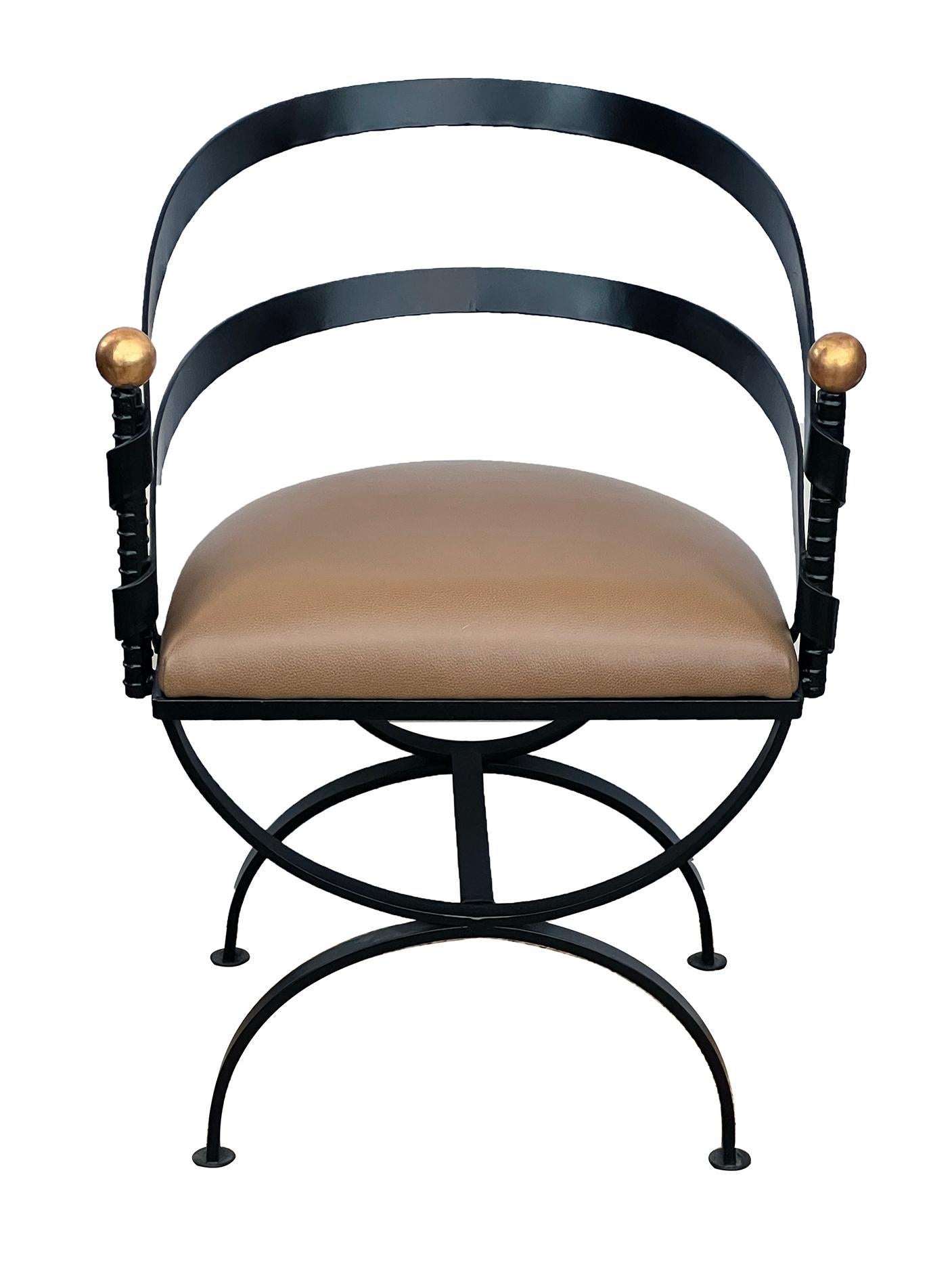 each with dramatic incurved openwork back sloping to upright teminals capped with giltwood spheres; flanking an attached leather seat all raised on a curule-form support