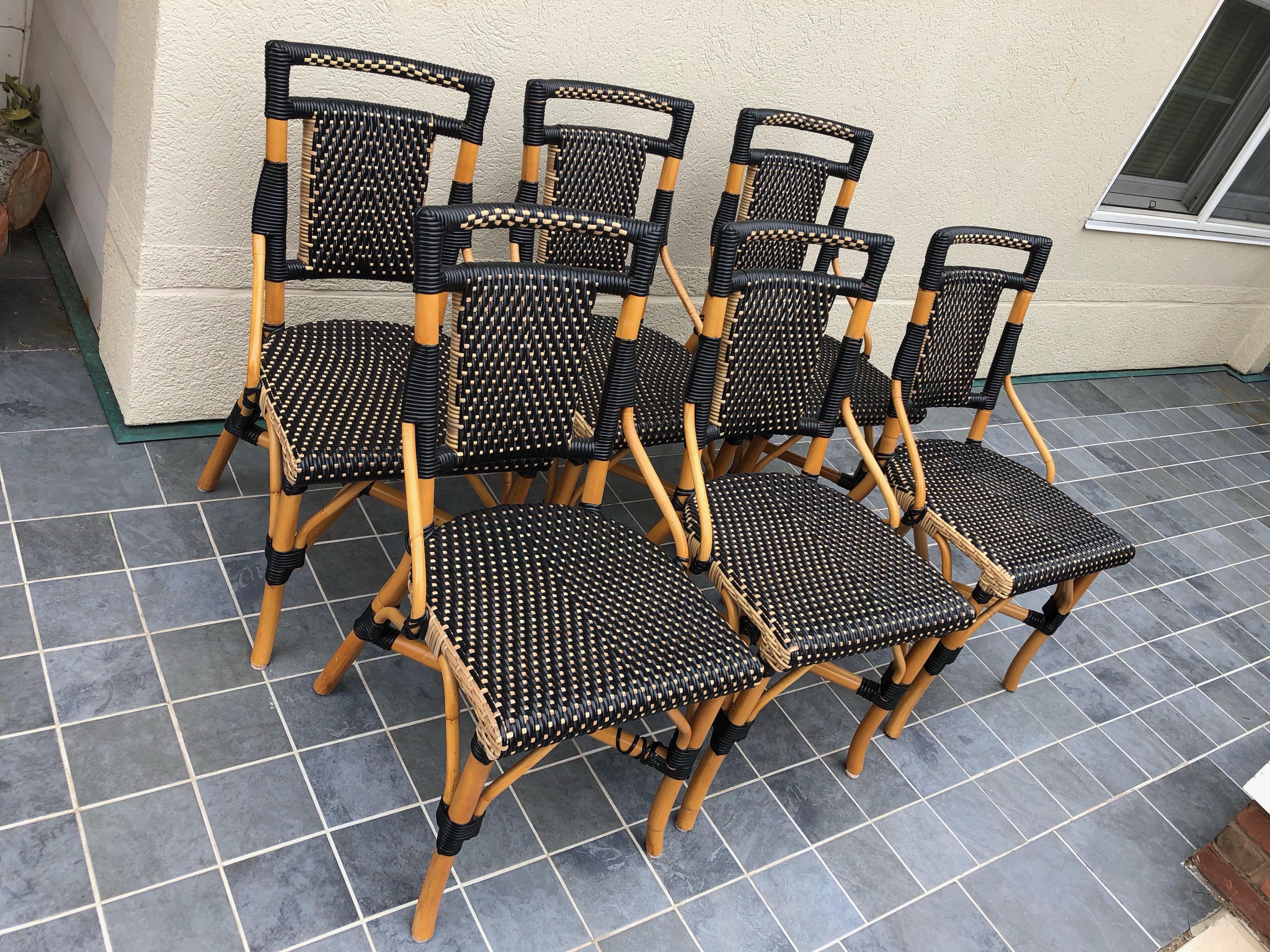 Handsome set of 6 bistro style chairs by Palecek constructed with bamboo rattan poles, wicker and synthetic rattan. Seat and back are in stylish contrasting black and beige colored pattern. Bamboo poles are a light honey color. 
Measures: seat