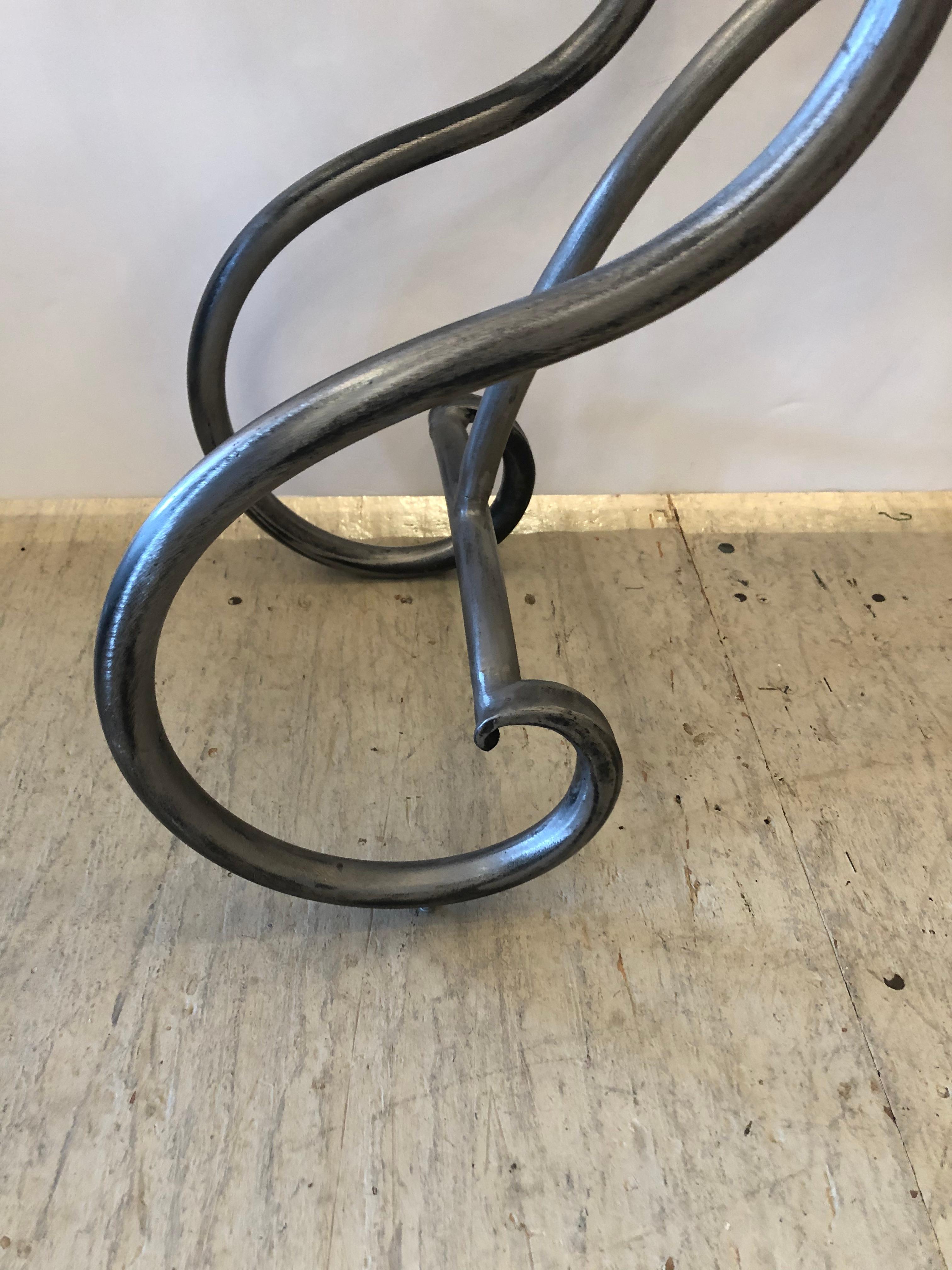 A stylish small narrow console table having versatile size and eye catching shape with brushed steel base, curlicue legs and decorative brass ball finials. 3/4