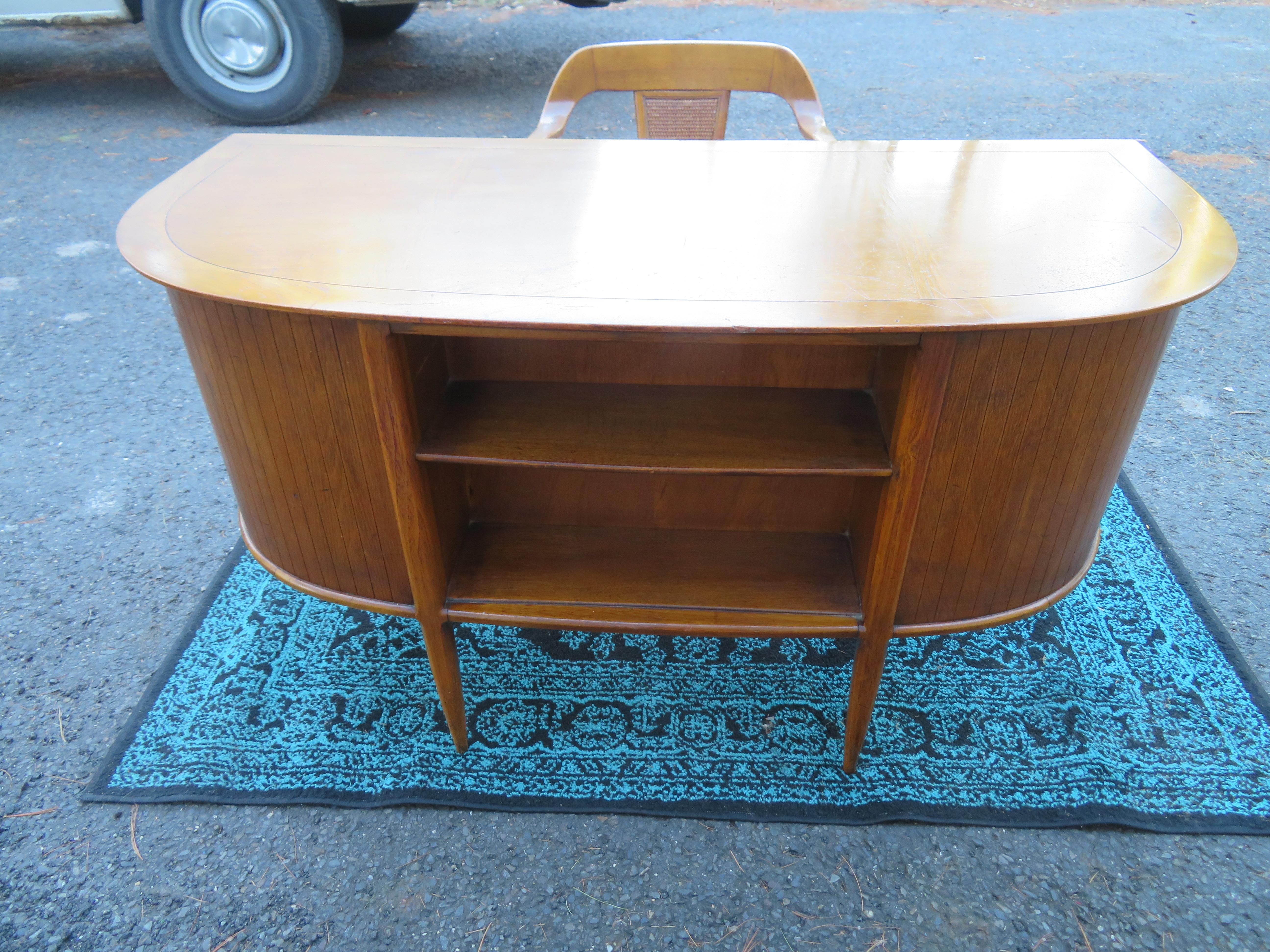 Stunning 1950s walnut desk by John Lubberts & Lambert Mulder for Tomlinson, from the Sophisticates collection. We love the stylish curved front with a built-in bookcase along with the five side drawers and a center drawer. Beautiful figured light