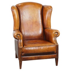 Stylish, spacious, comfortable sheepskin leather wingback chair in a warm color