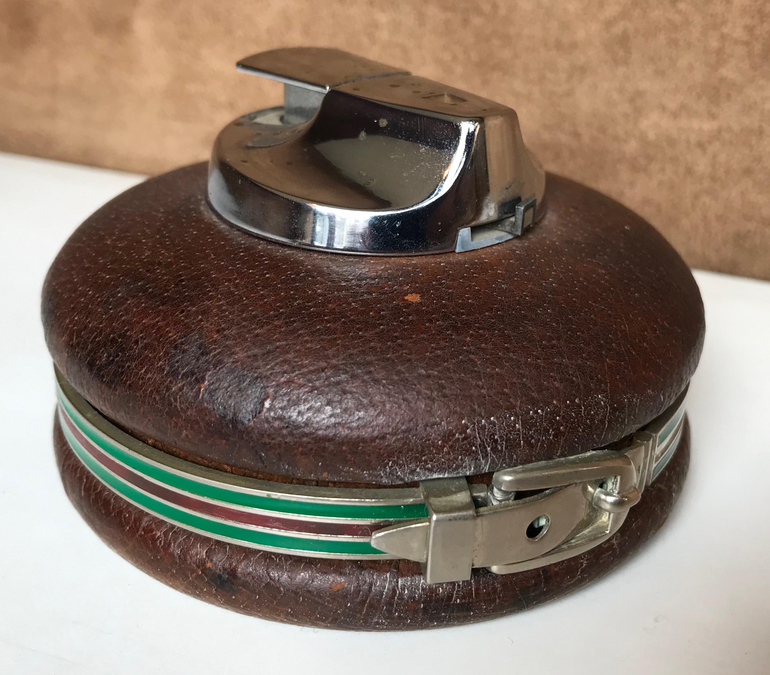 Spherical leather Gucci lighter, made in Italy, 1980s
A stylish circular silver leather lighter by Gucci, with a leather band around the body in the signature Gucci colors of green and red
Marked Gucci MADE IN ITALY to the base.